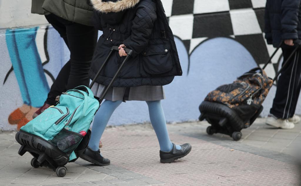 Varios escolares, con sus mochilas, entran en un colegio de Madrid.