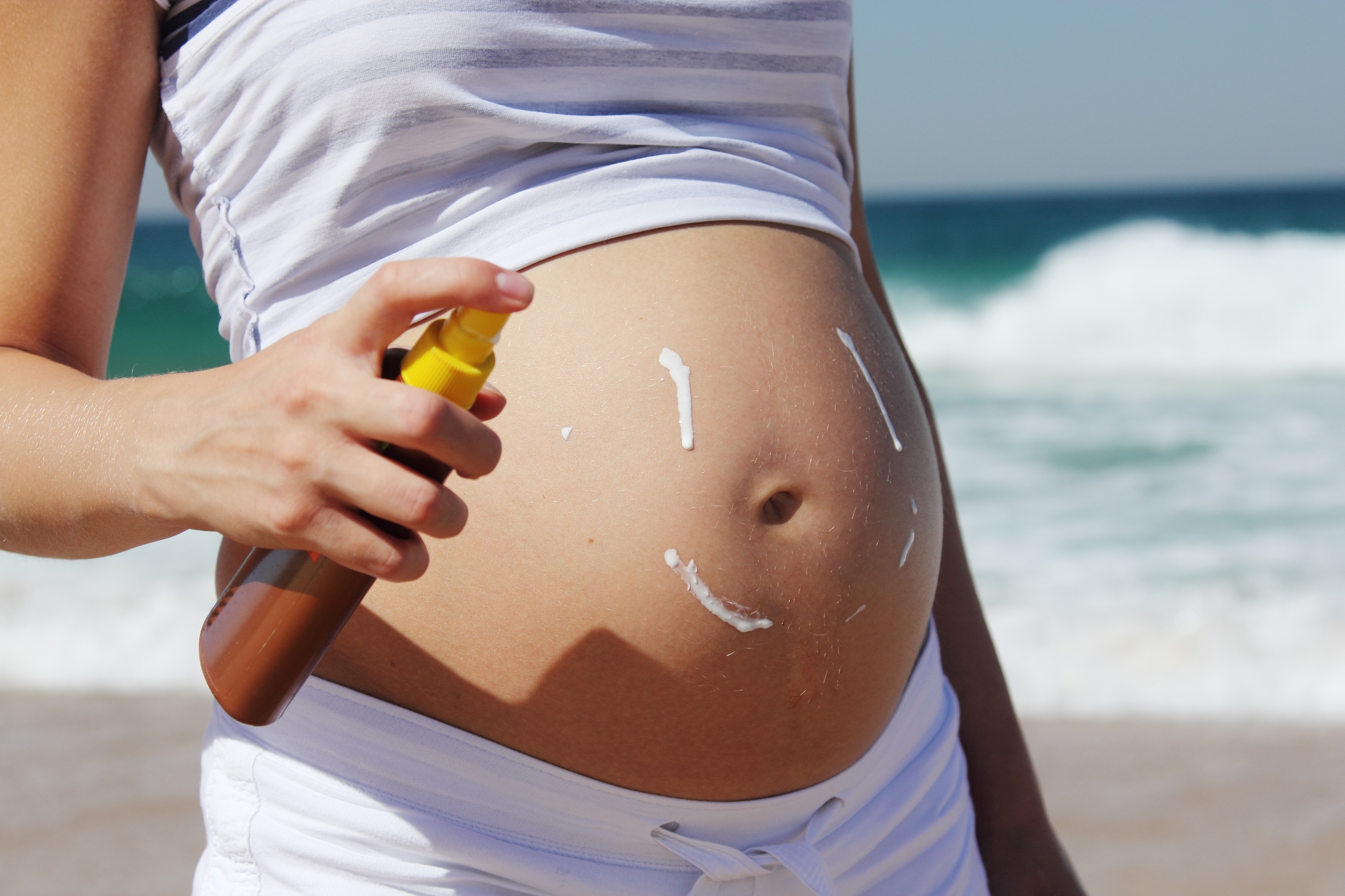 Una mujer embarazada con crema solar.