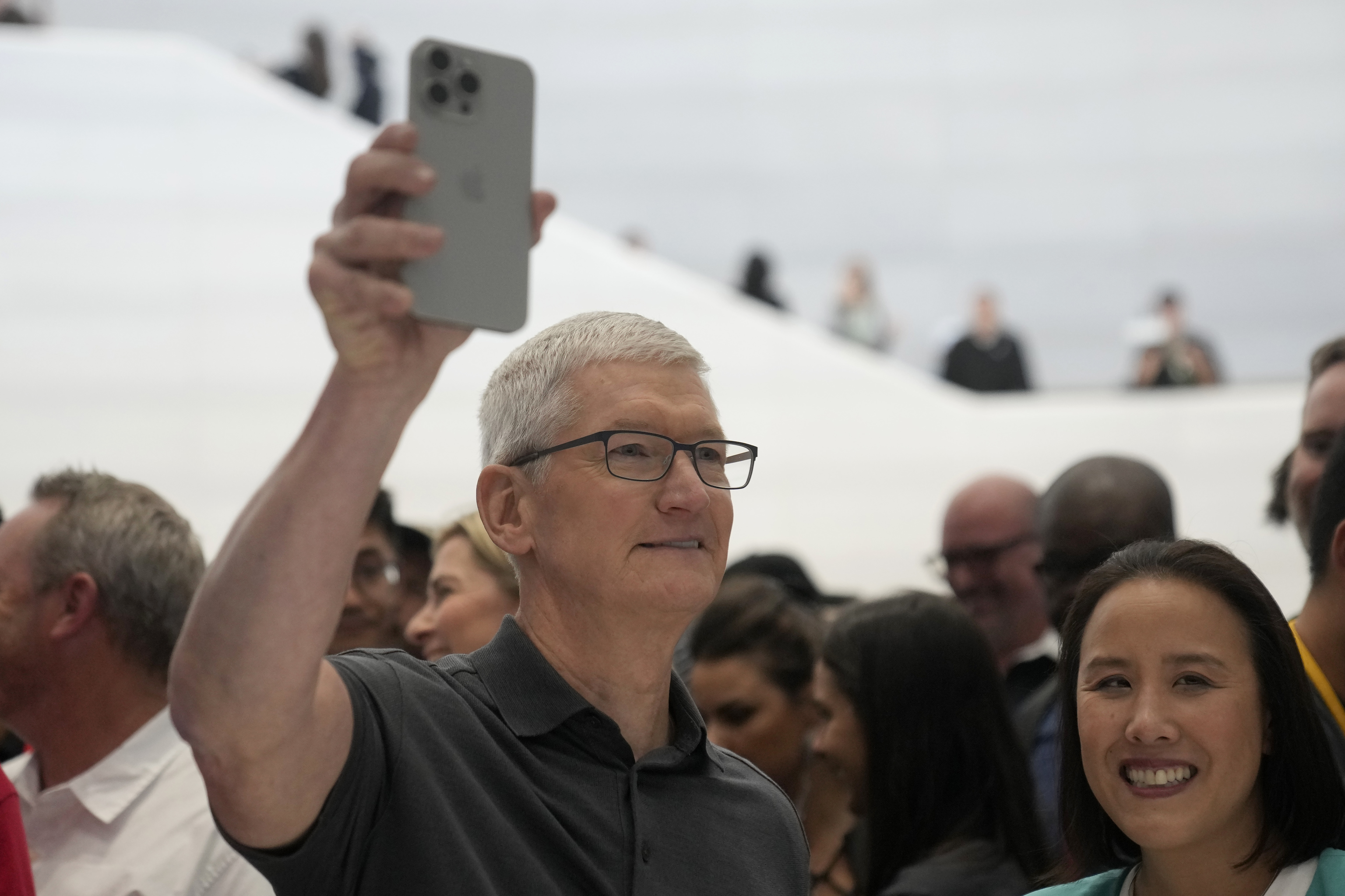 Tim Cook sostiene un iPhone durante un campus de Apple.