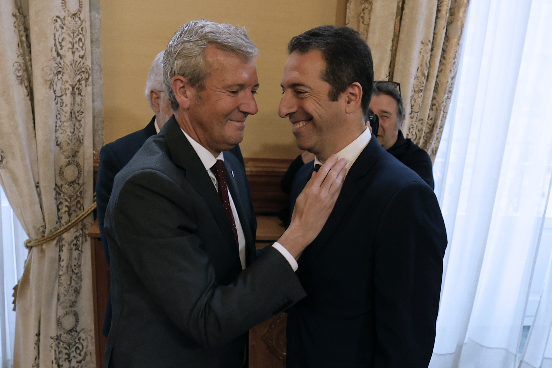 El presidente de la Xunta, Alfonso Rueda (i), saluda a Alfonso Villares durante la toma de posesión para su sustitución en junio de 2025