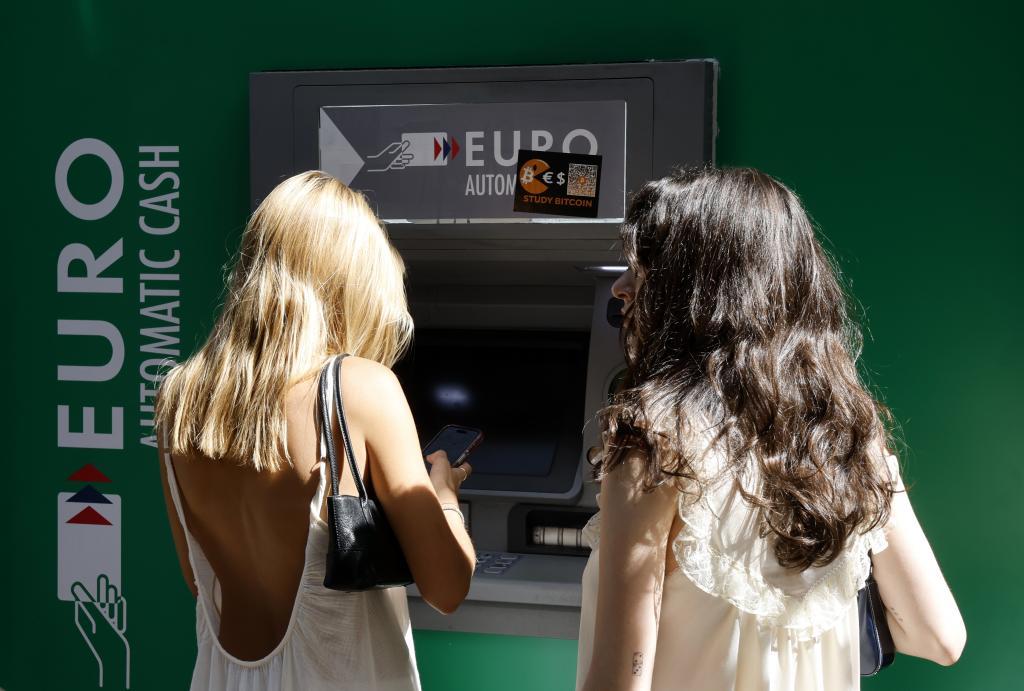 Una mujer saca dinero de un cajero en el centro de Madrid