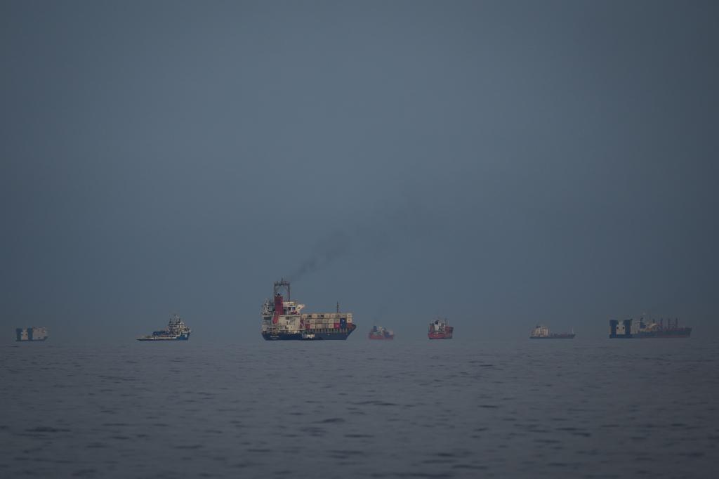 Petroleros y mercantes esperan en el Estrecho de Ormuz vistos desde Emiratos Árabes Unidos, el sábado.