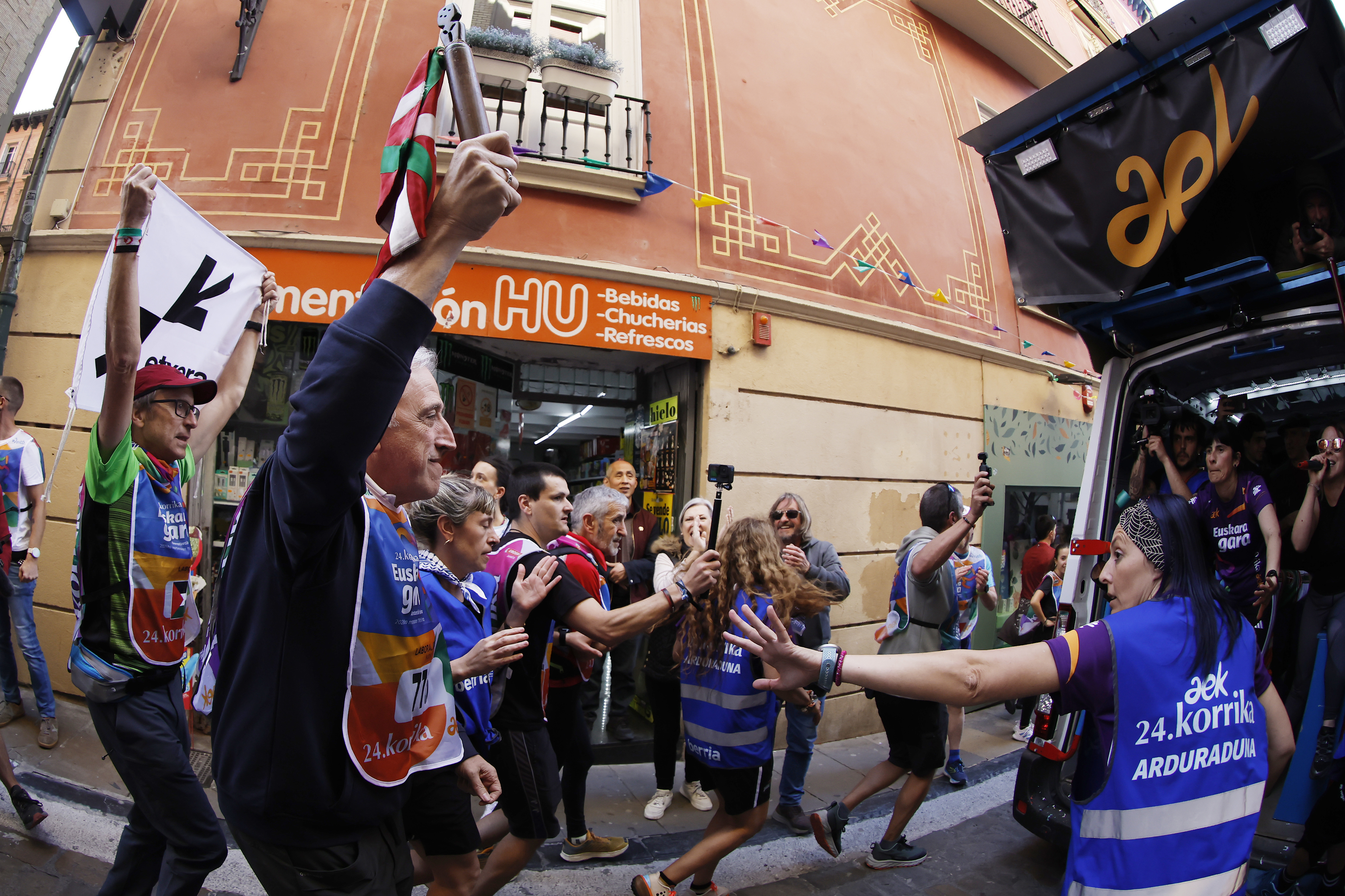 El alcalde de Pamplona Joseba Asiron (EH Bildu) alza el testigo de la Korrika acompañado por un simpatizante con un cartel que reivindica la puesta en liberad de los presos de ETA.