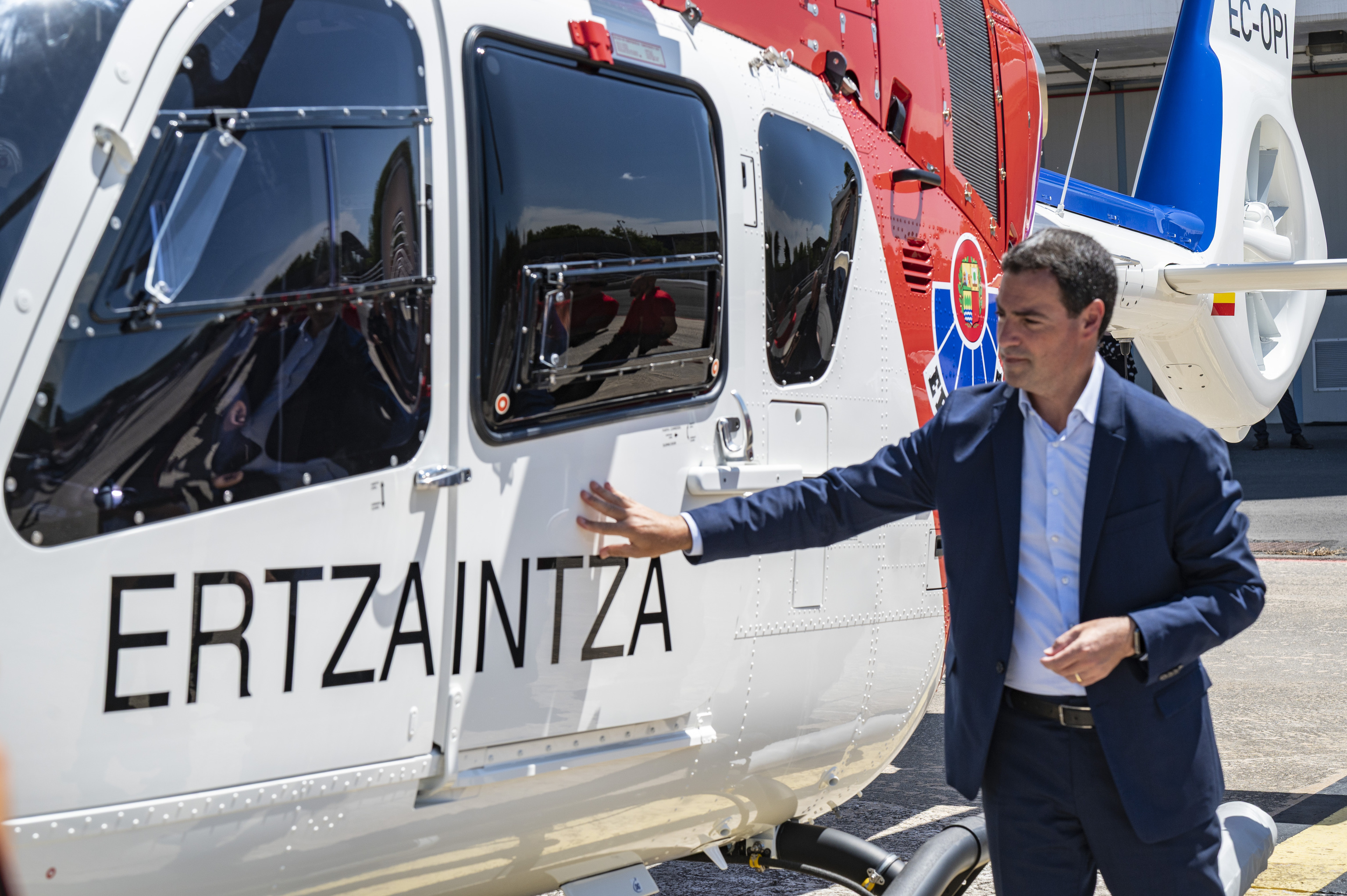 El lehendakari Imanol Pradales junto a uno de los nuevos helicópteros de la Ertzaintza en la base de Iurreta (Bizkaia).