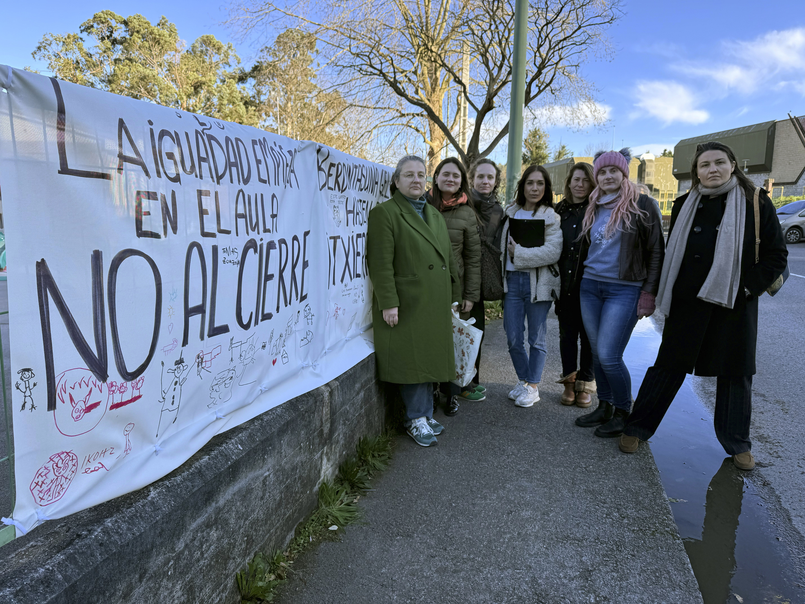 Madres de escolares del colegio de Larrañazubi posan junto a la pancarta situada en una las vallas del colegio público situado en Getxo.