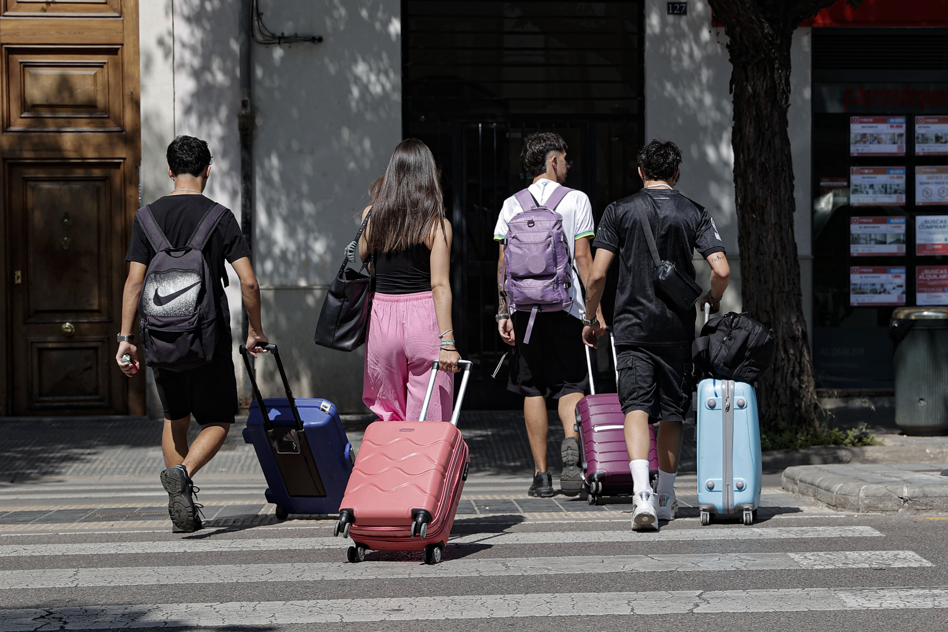 Varios visitantes arrastran maletas hasta sus alojamientos en Valencia.
