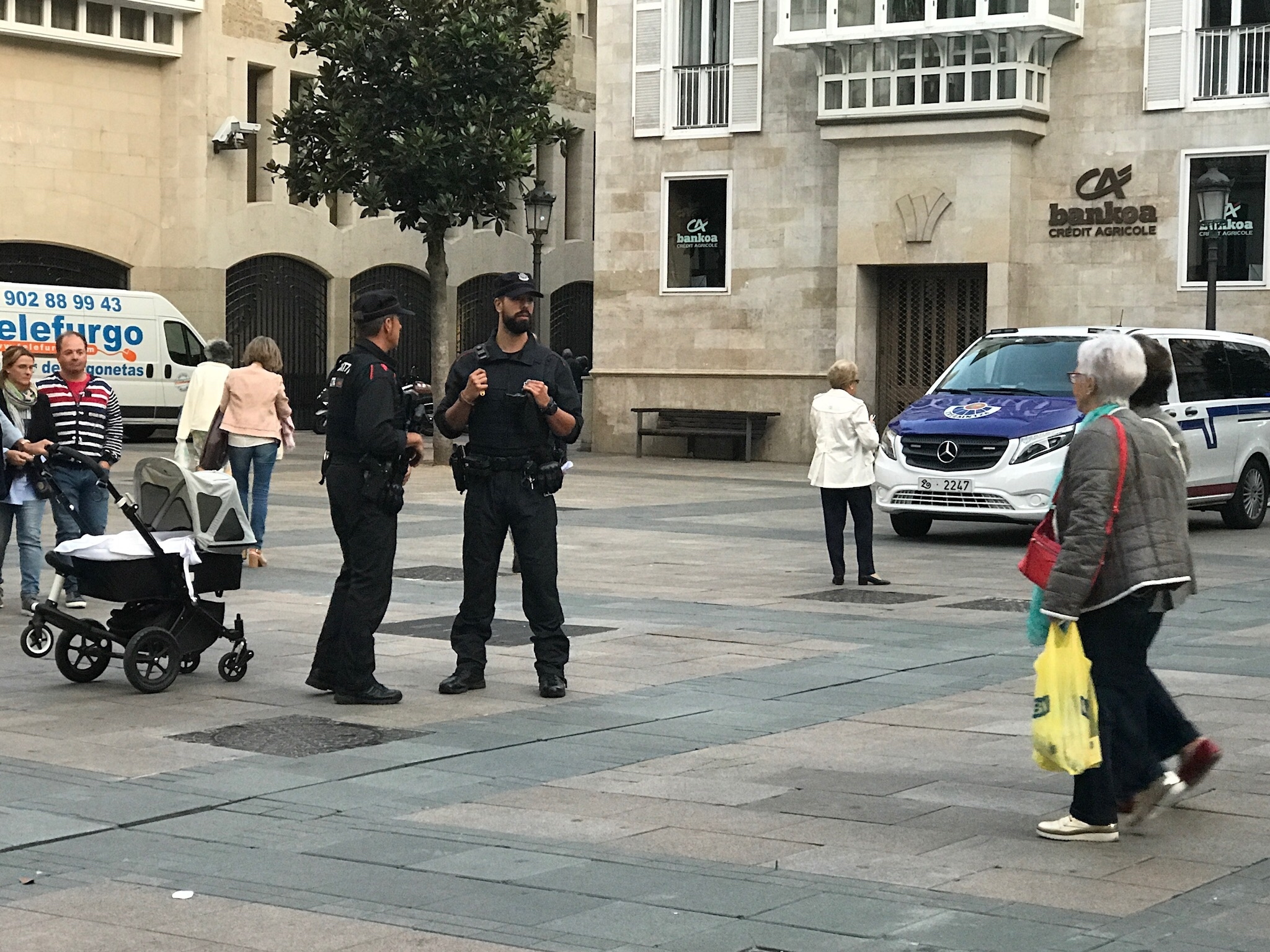 Dos ertzainas observan a los peatones que caminan por la plaza del Arca de la capital alavesa.