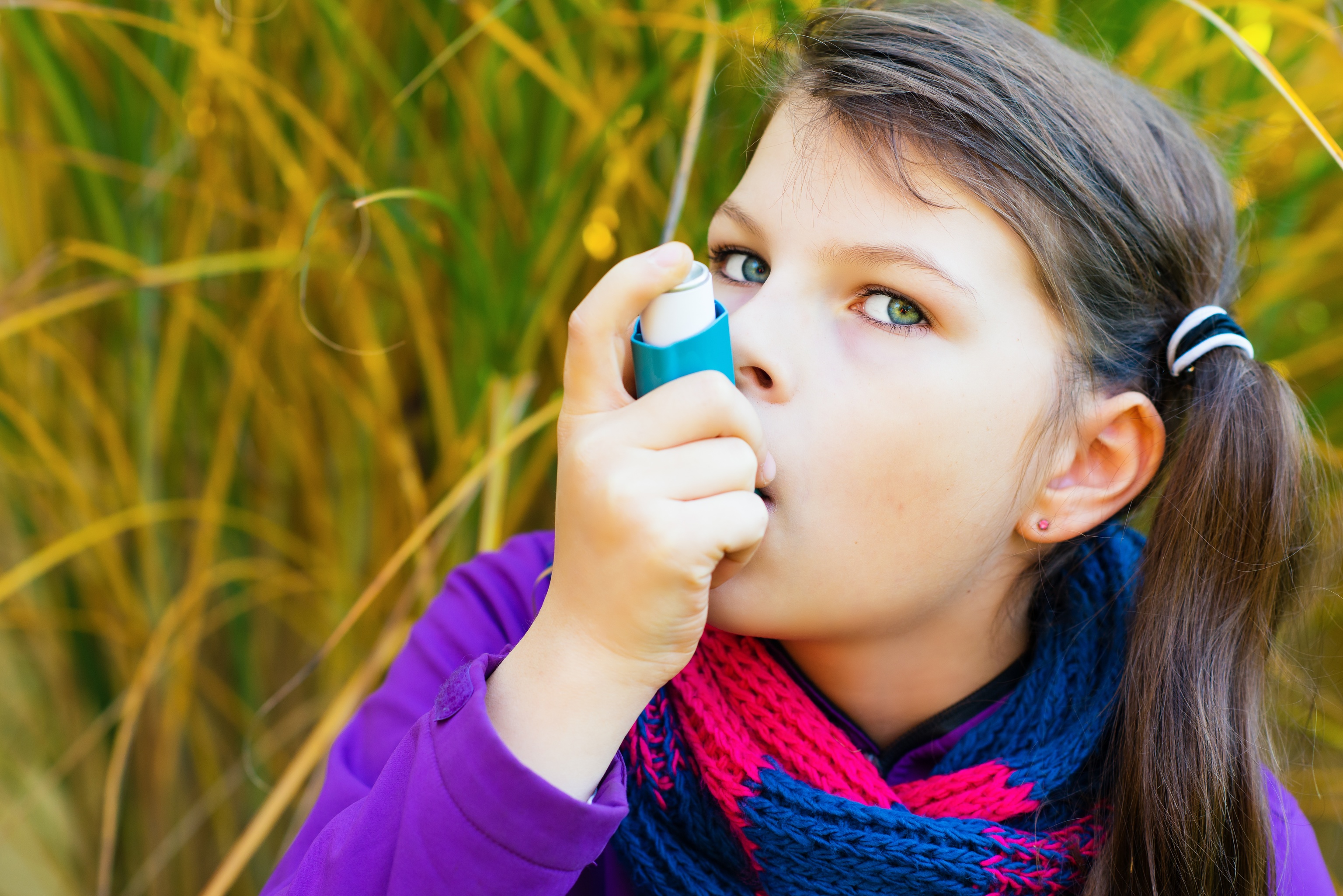 Una niña utiliza un inhalador para el asma.