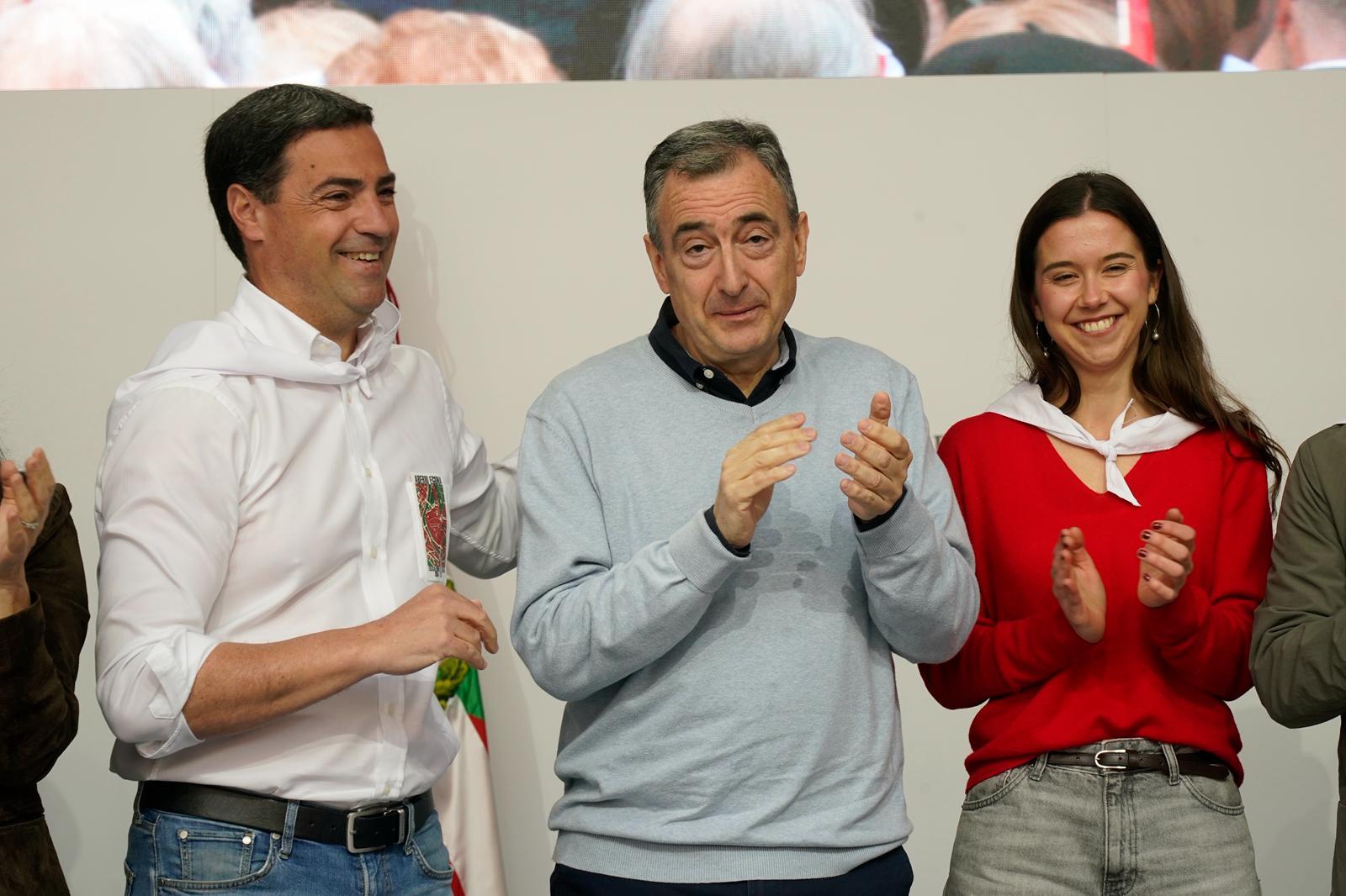 El lehendakari Imanol Pradales junto al presidente del PNV Aitor Esteban y una joven afiliada del PNV durante el mitin celebrado en la plaza Nueva de Bilbao.