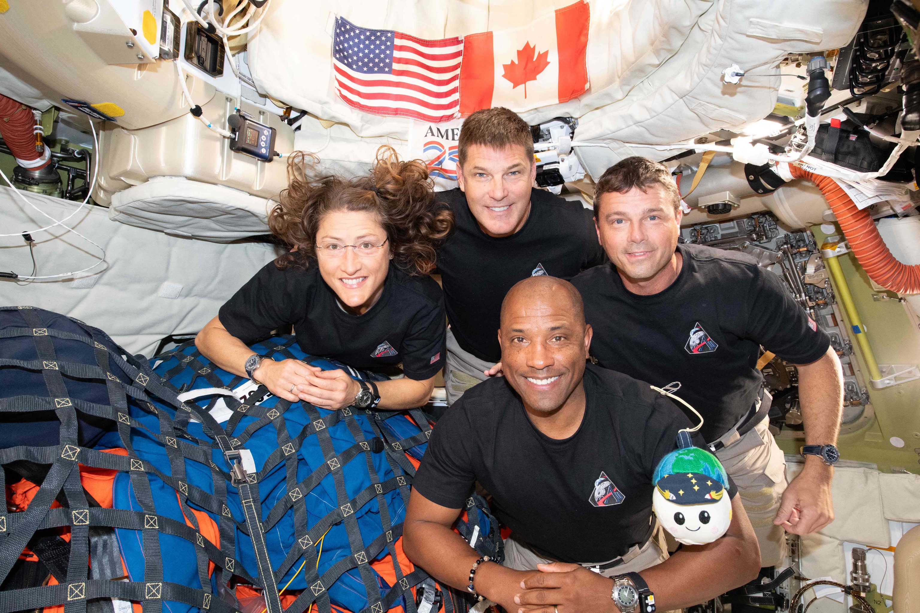 Chrstina Koch, Victor Glover, Jeremy Hansen y Reid Wiseman con la mascota Rise, ayer en la nave Orión