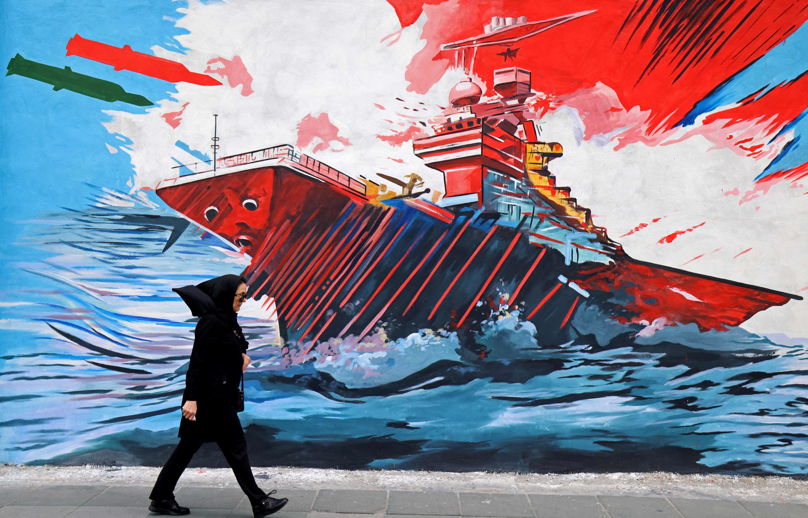 Una mujer pasa junto a un mural en contra de Estados Unidos e Israel, en Teherán, este miércoles.
