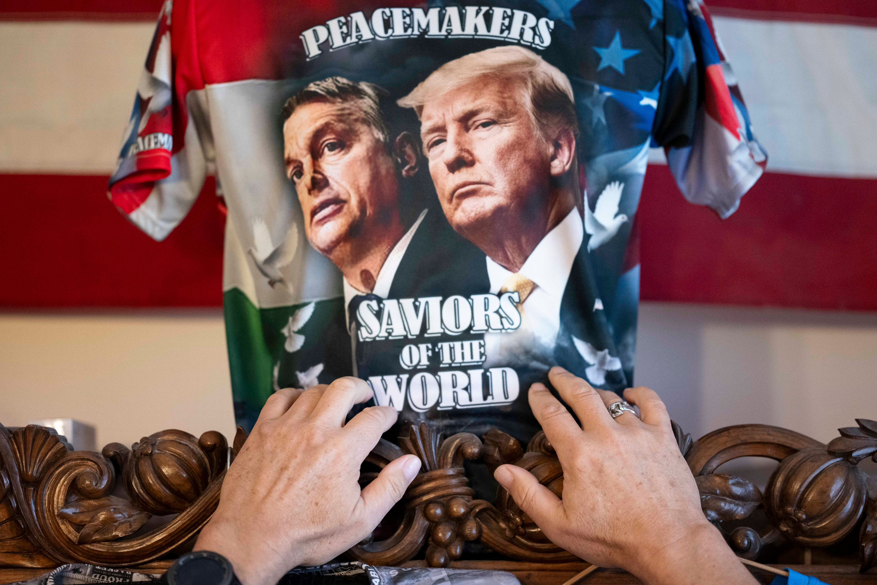 Un partidario de Orban enseña una camiseta con su rostro y el de Trump en Budapest.