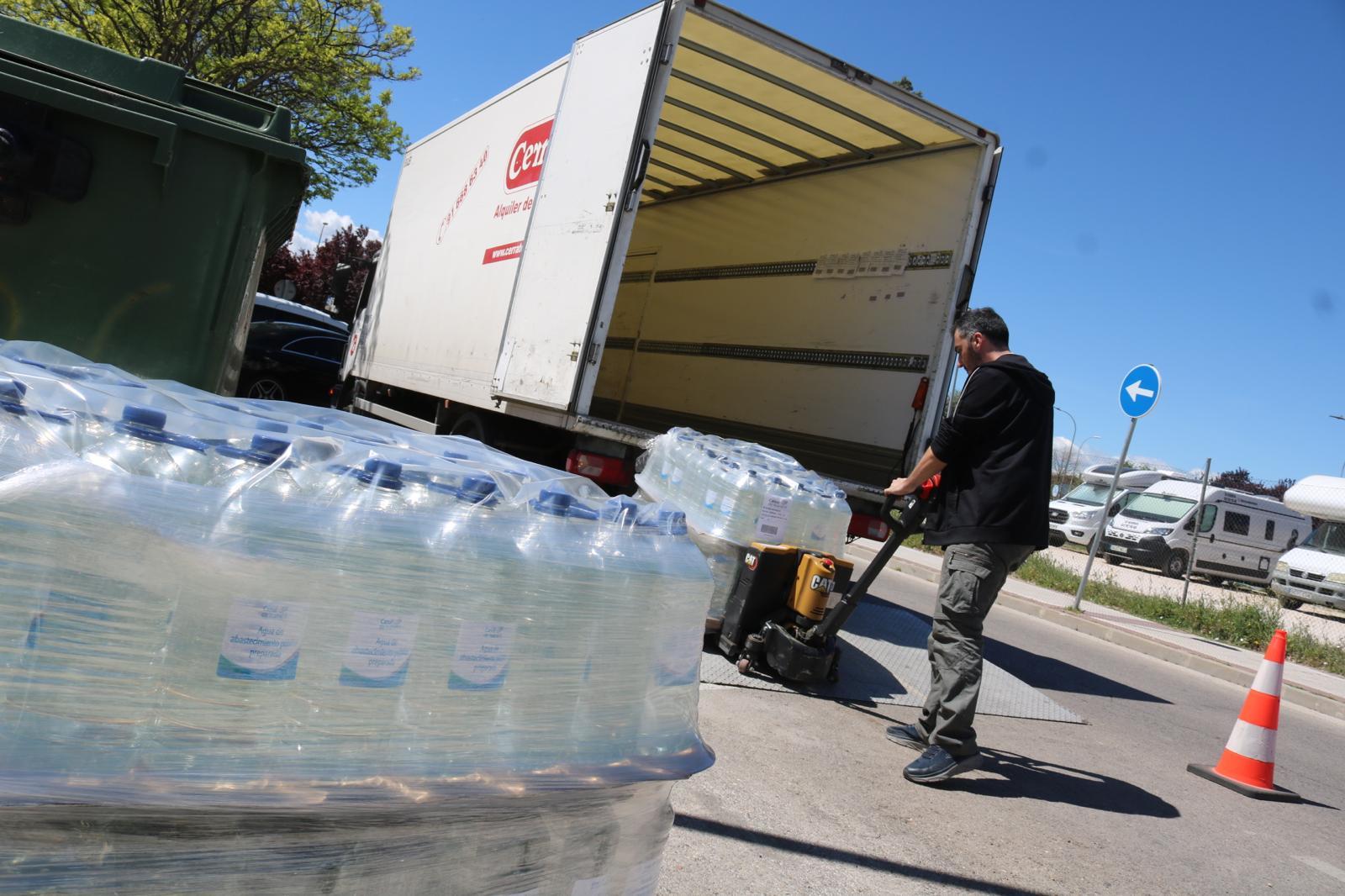 Operarios descargando garrafas de agua para los vecinos