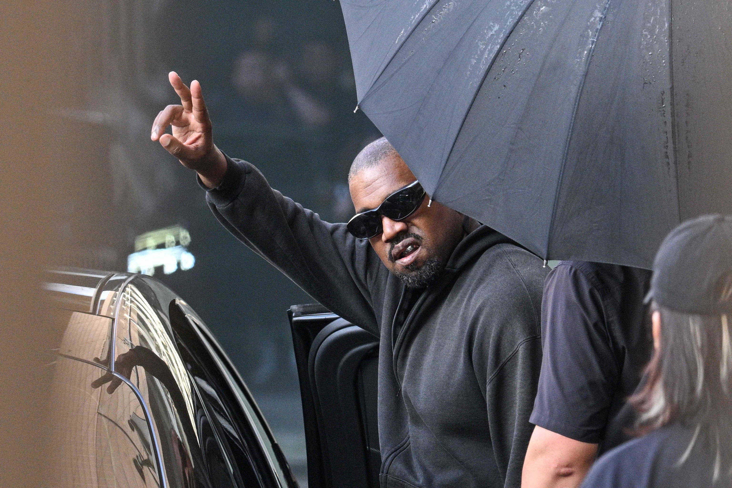 El rapero y productor estadounidense Kanye West hace un gesto a su llegada al Aeropuerto Internacional de Shanghái-Pudong el 11 de julio de 2025