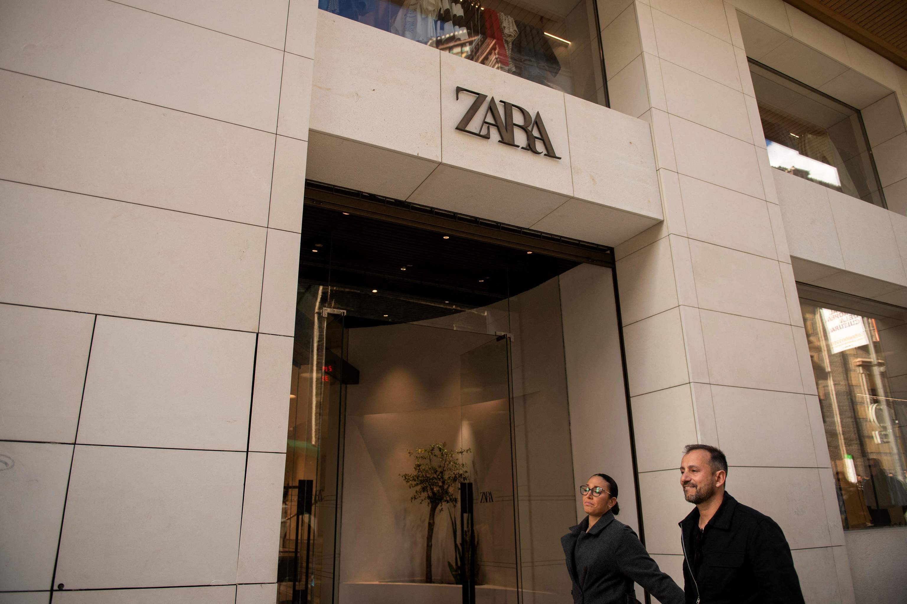 Una pareja pasea frente a una tienda de Zara en Granada.