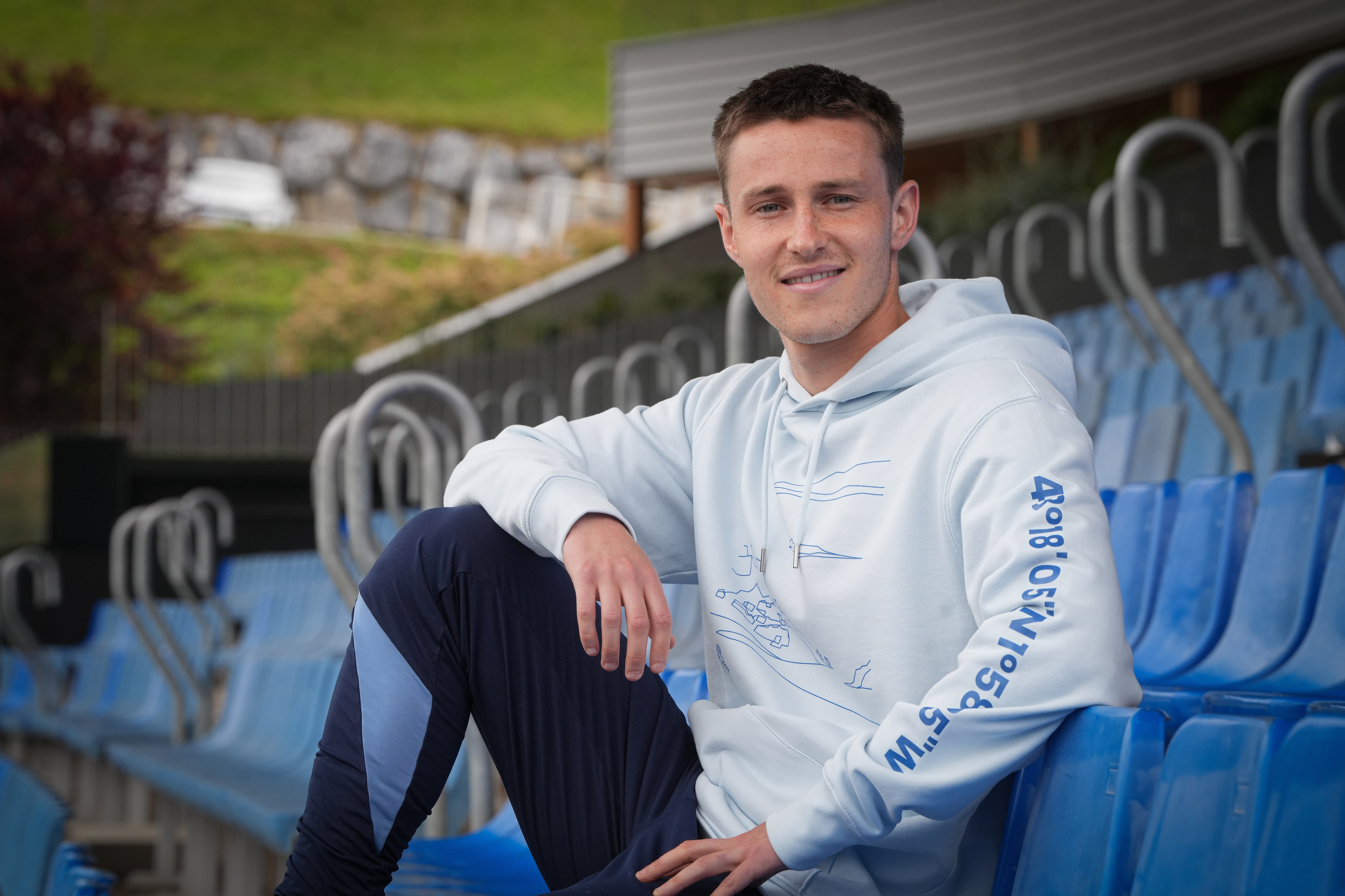 El centrocampista en las gradas del campo de entrenamiento.