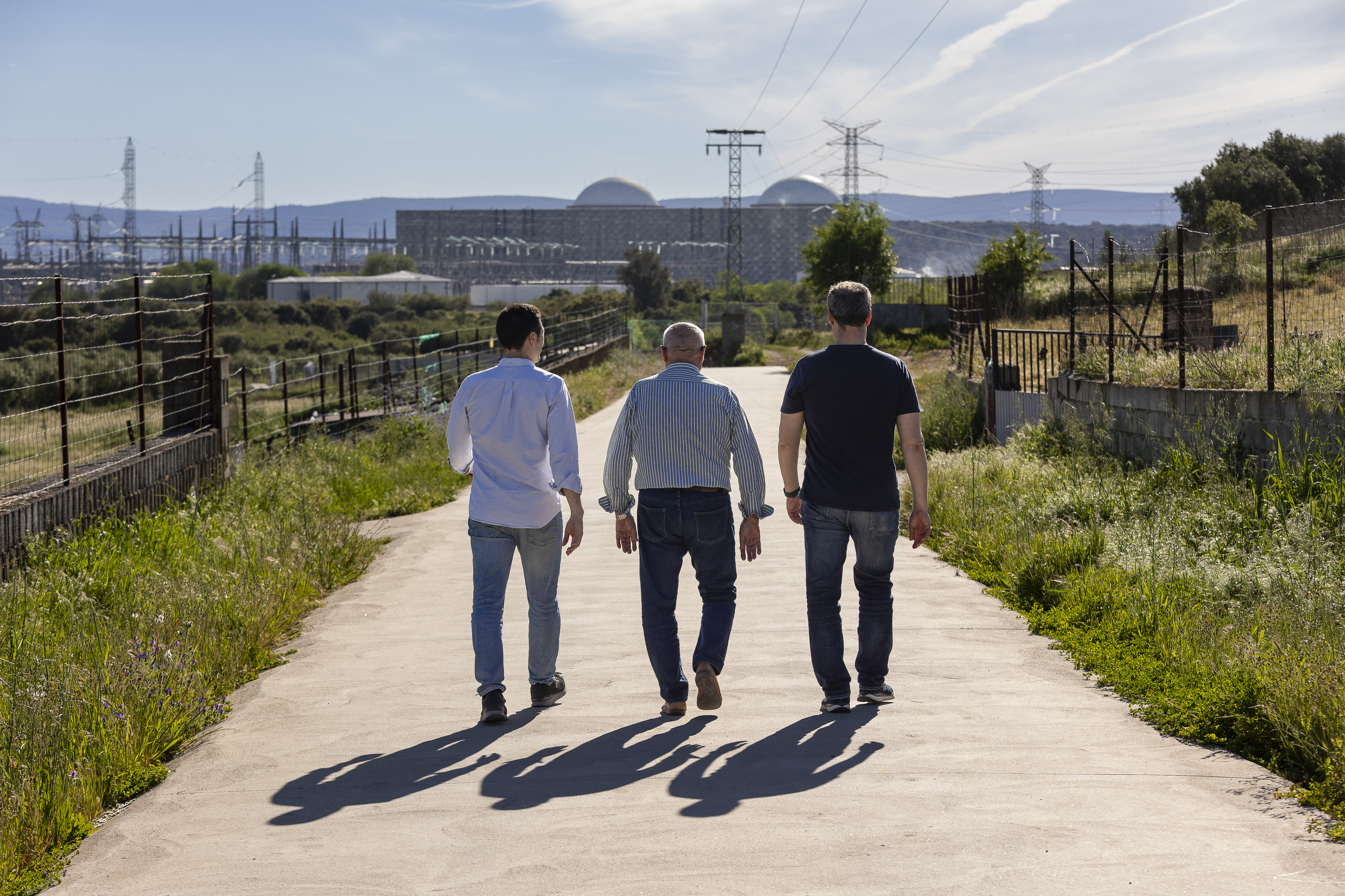 Ciriaco y sus hijos caminan en una calle de Almaraz mientras observan la central nuclear