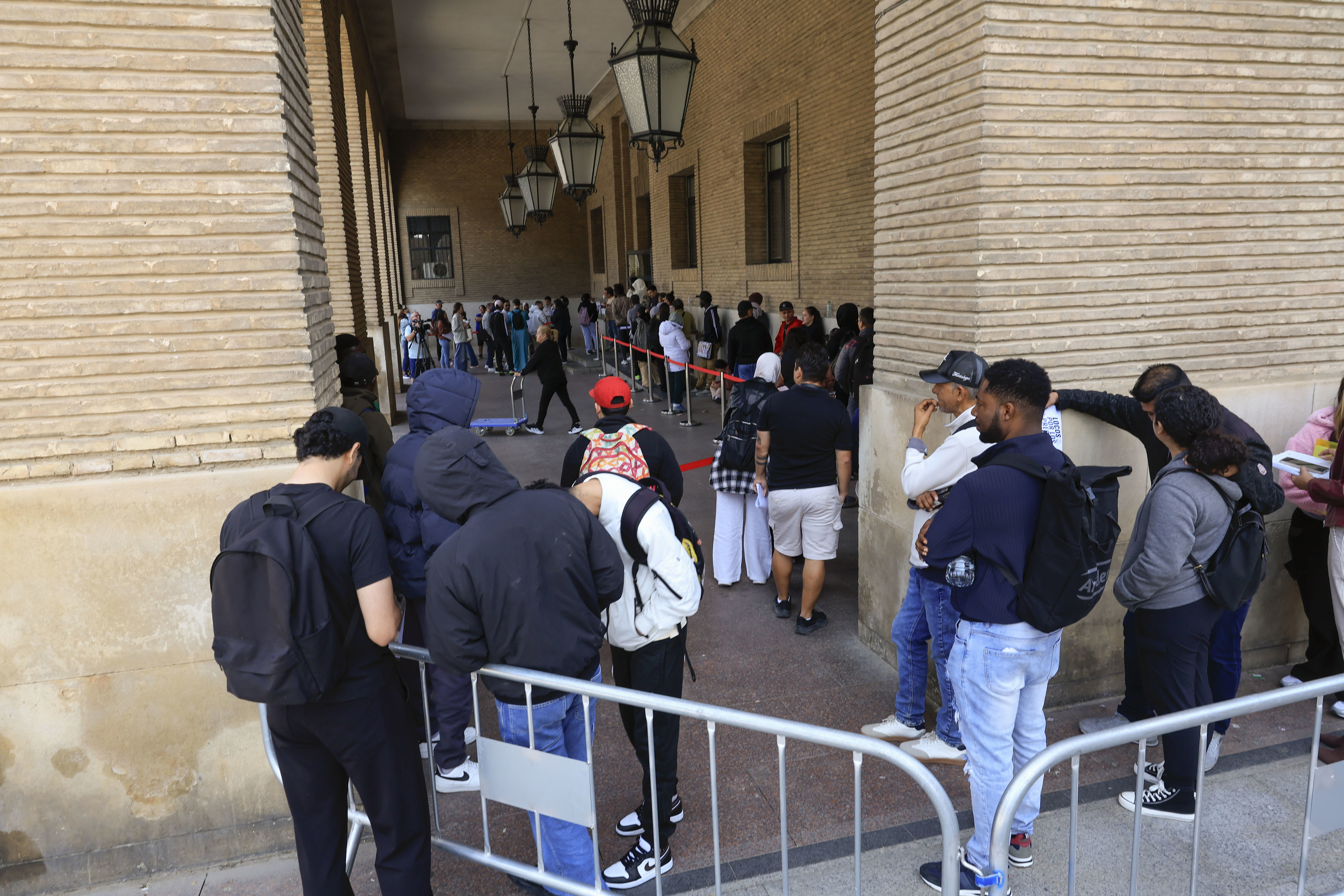 Extranjeros aguardan frente al Ayuntamiento de Zaragoza para conseguir la documentación de la regularización.