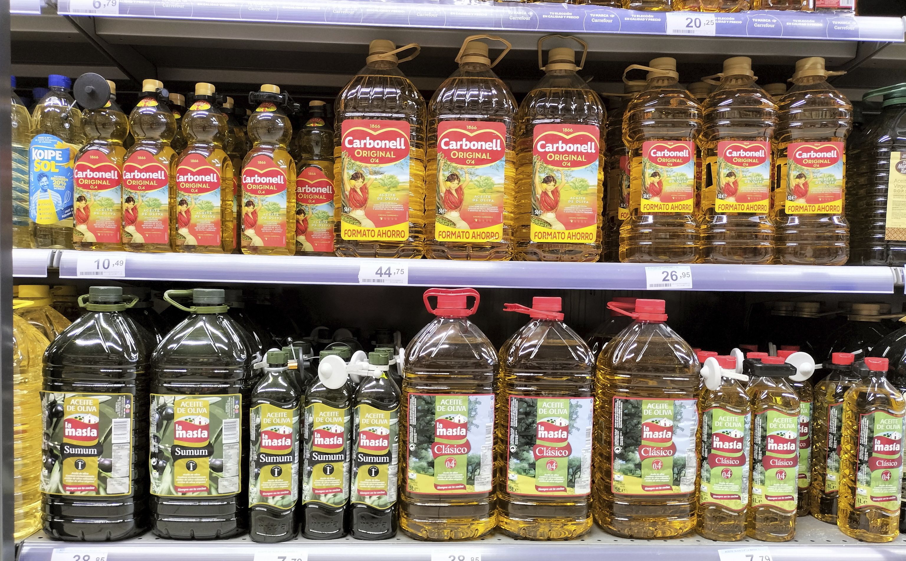 Botellas de aceite de oliva en una estantería de un supermercado