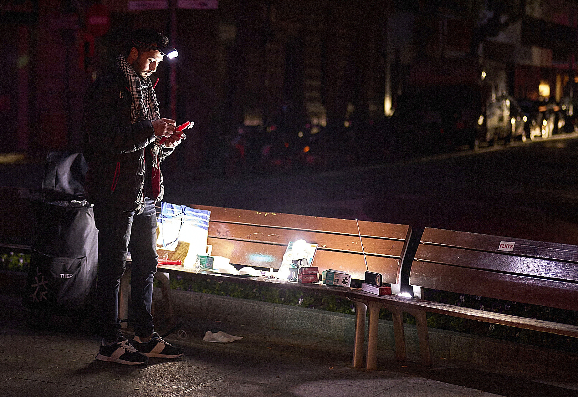 Un hombre vende radios y linternas a pilas en una calle de Barcelona durante el apagón del 29 de abril de 2025