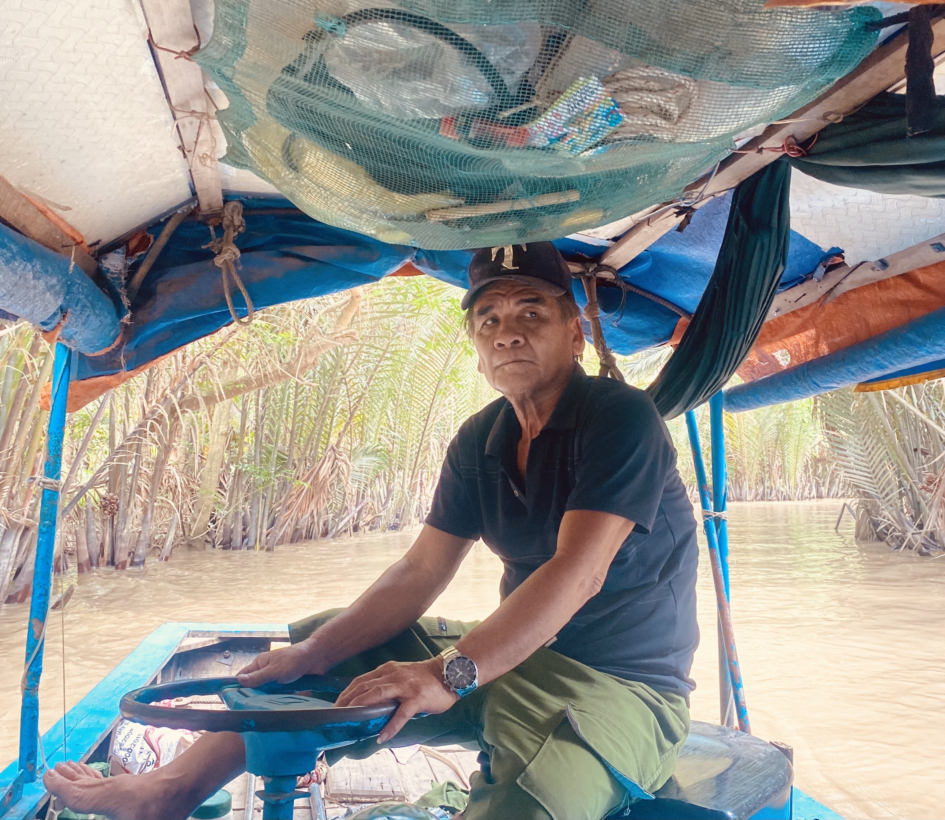 El señor Phuc conduce un barco por uno de las pequeñas arterias del Mekong.