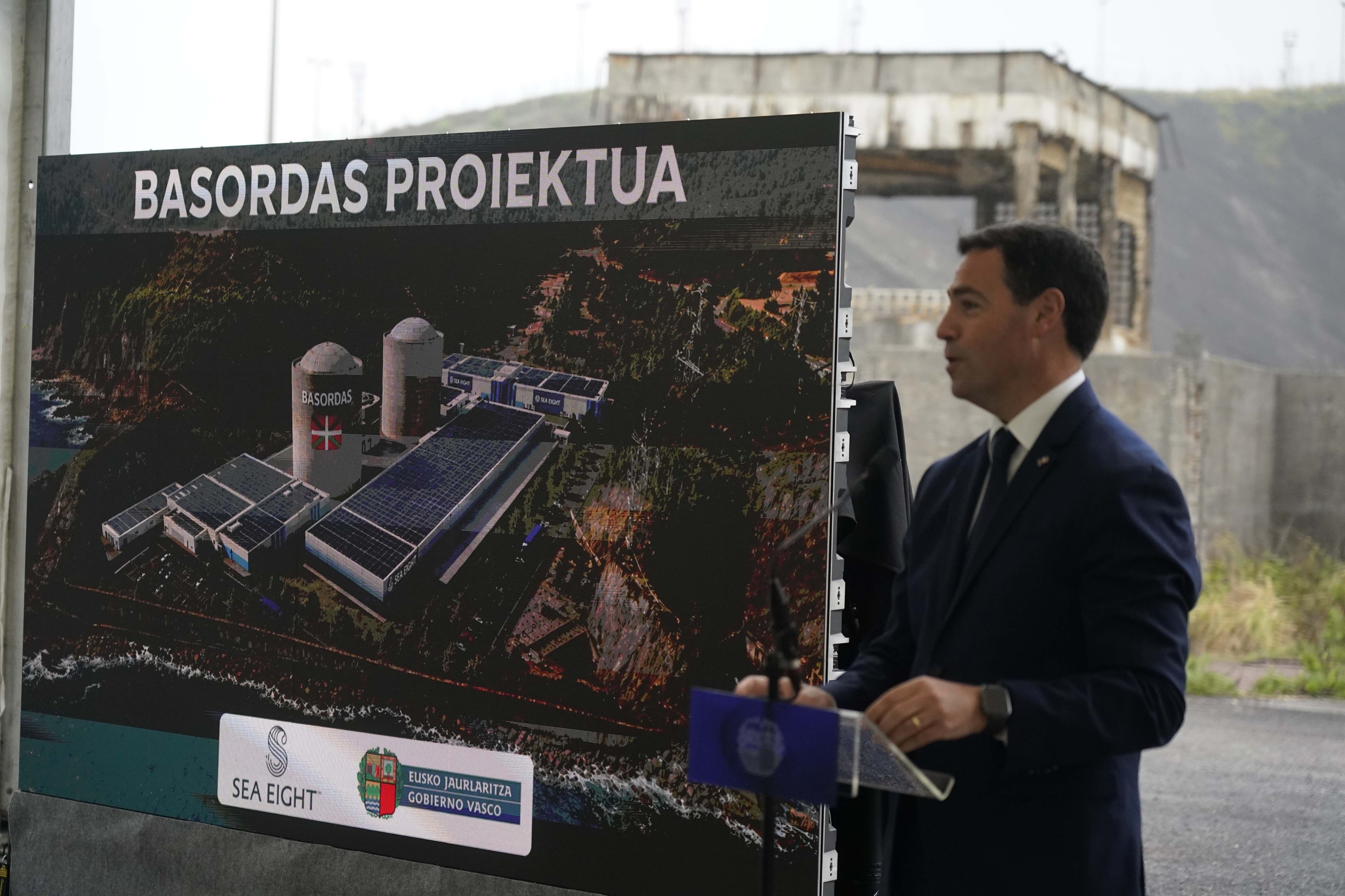 El lehendakari Pradales posa con la infograf�a que recrea la reconversi�n de la central en una piscifactor�a en la que destaca la ikurri�a pintada sobre uno de los reactores nuclearos construidos por Iberduero.