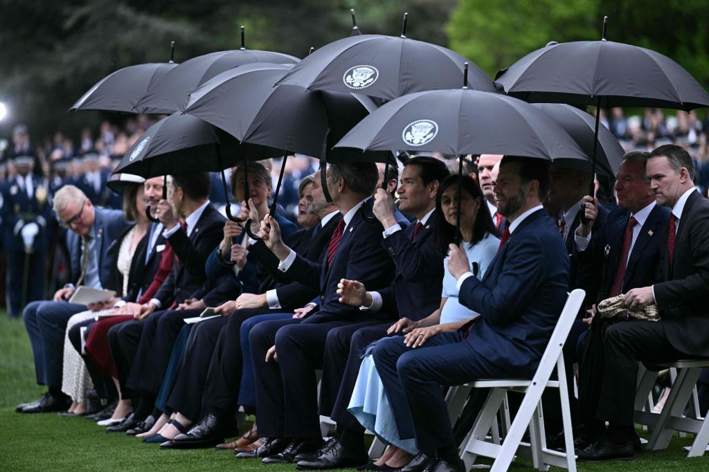 Invitados en el jardín de la Casa Blanca, bajo los paraguas.