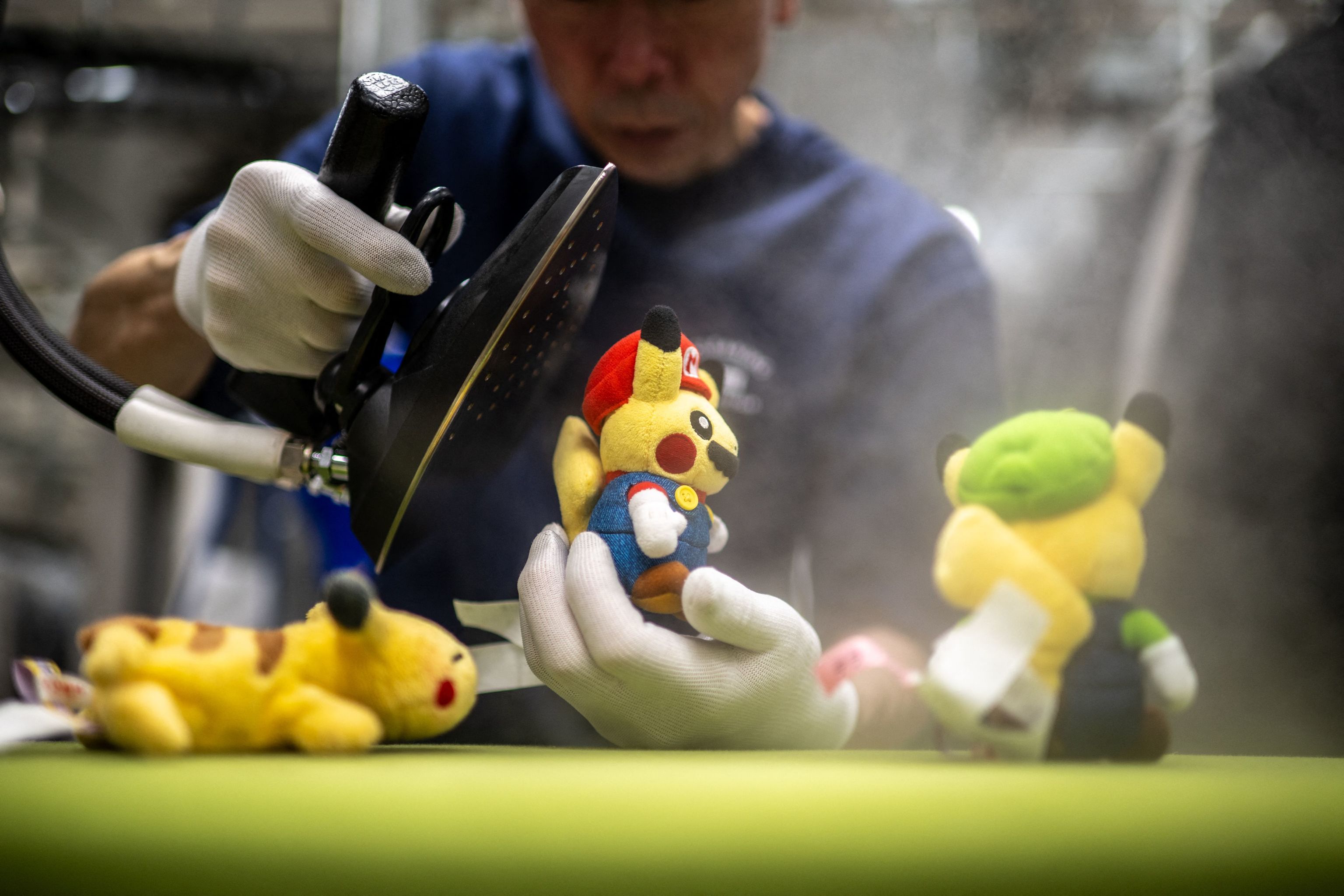 Un empleado de Cleaning Yonmarusan aseando a unos peluches.