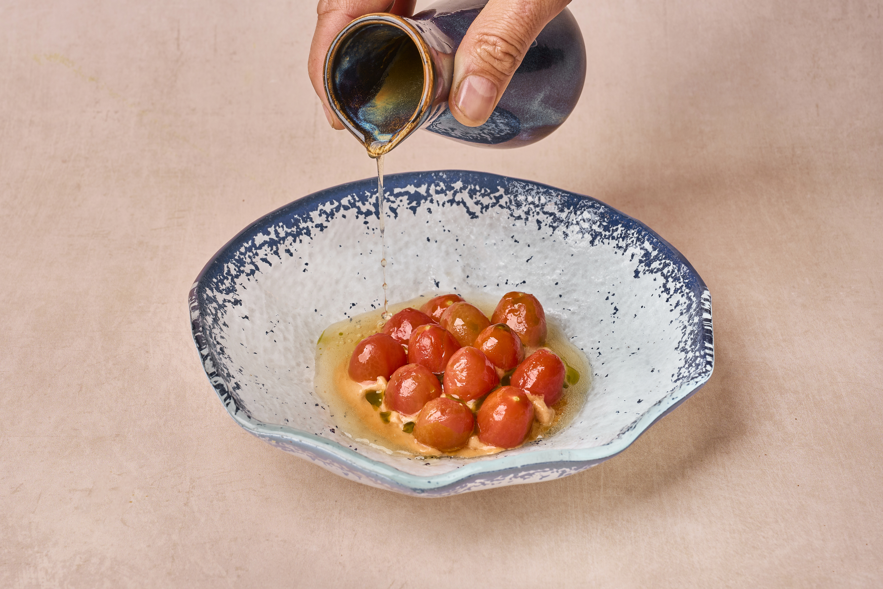 Tomates 'cherries' aliñados, acompañados de burrata, pesto y brotes, en Quintoelemento.