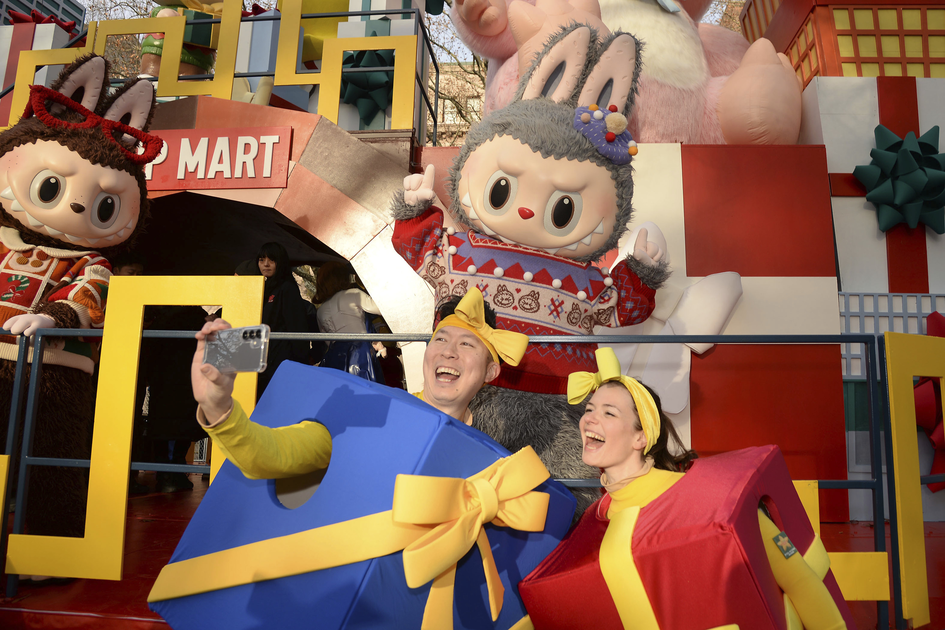Dos personas se hacen una foto en una tienda que vende peluches labubu.