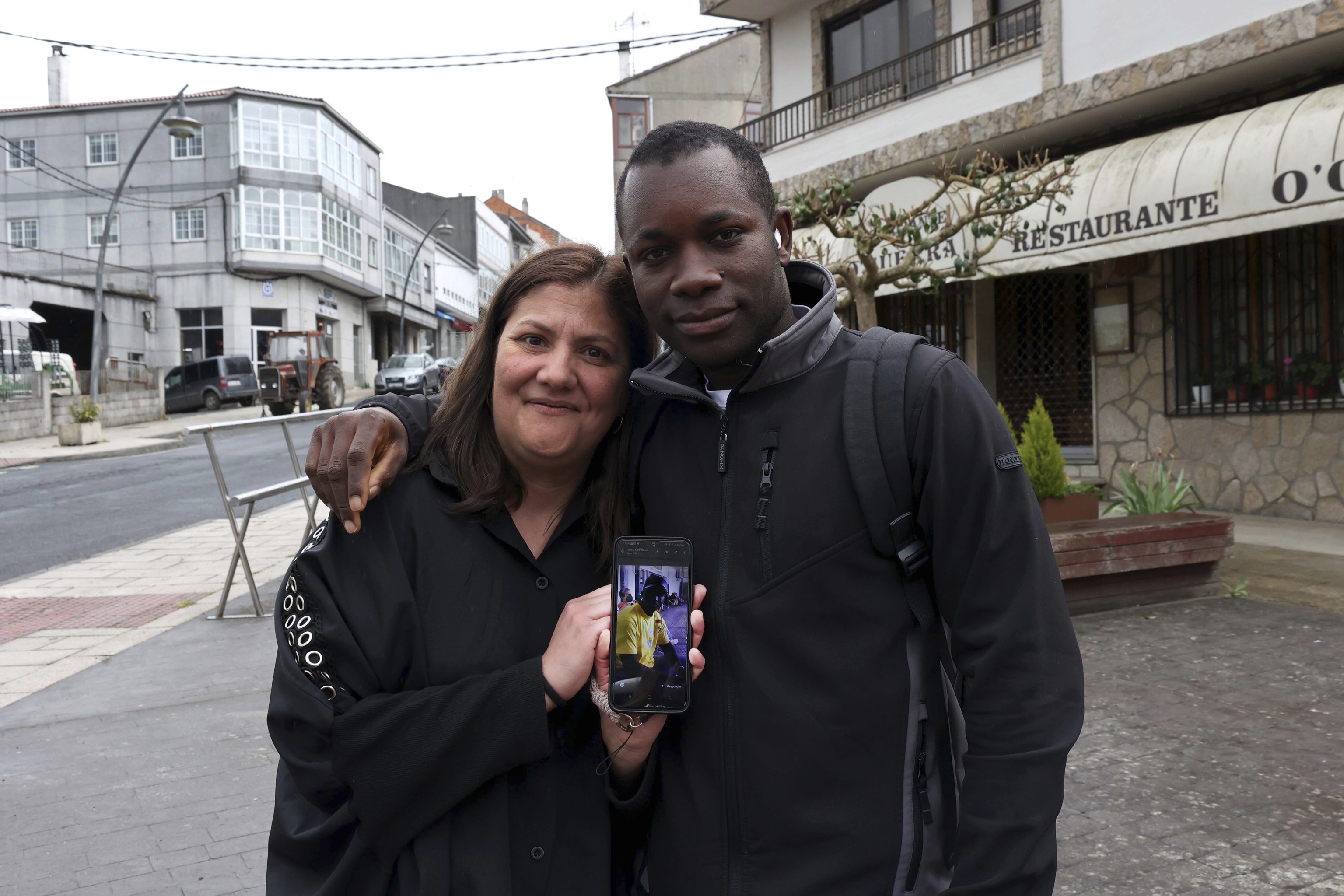 Noelia y Mor sostienen un teléfono con la imagen de su amigo Samba.