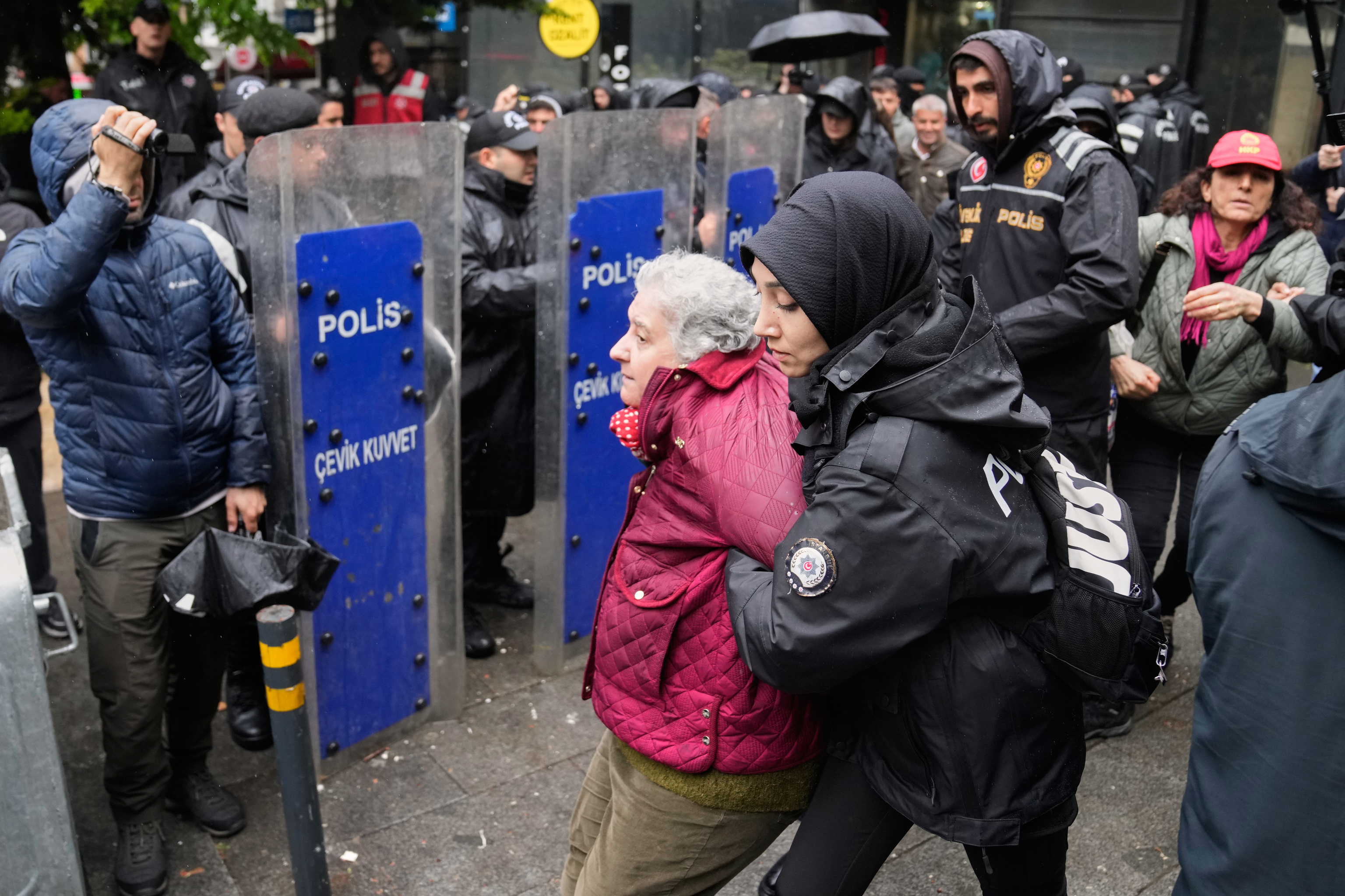Una polic�a detiene a una mujer mayor en Estambul.