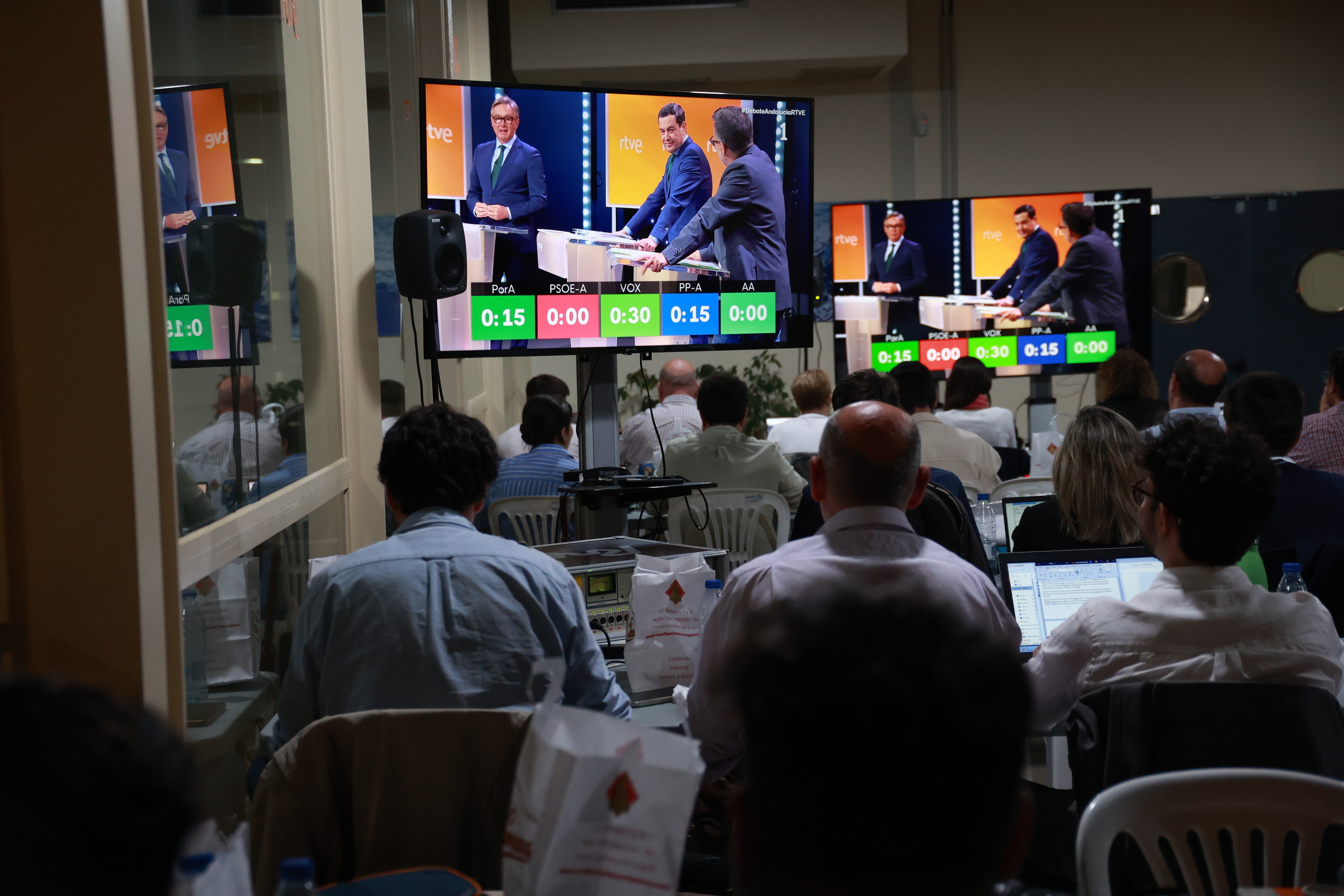 Los periodistas acreditados siguen el debate electoral en la sede de RTVE en Andalucía.