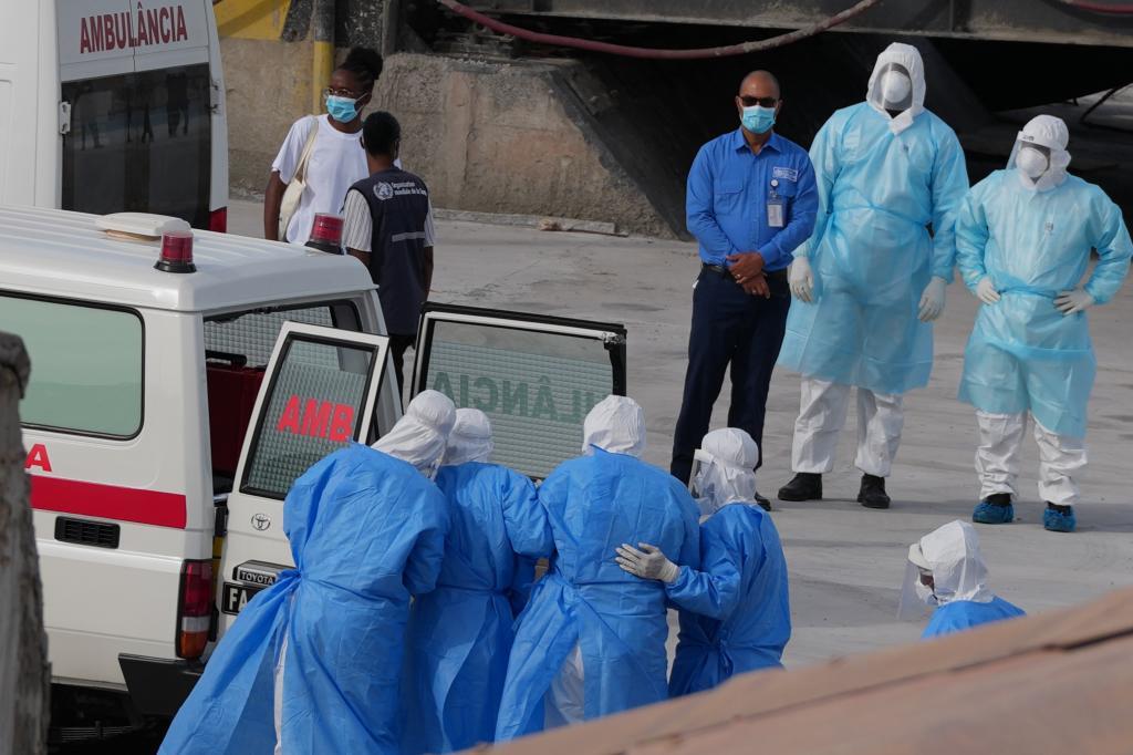 Personal sanitario con equipo de protecci�n evacua a pacientes del crucero MV Hondius a una ambulancia.