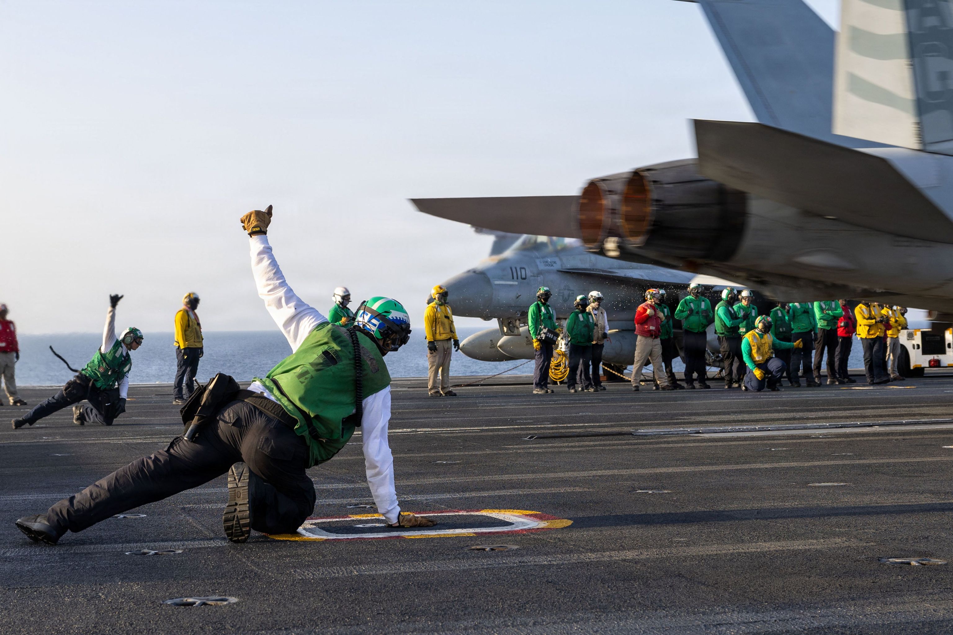 Marineros estadounidenses dan la señal de despegue de un EA-18G a bordo del USS George H.W. Bush en alta mar, a finales de abril.