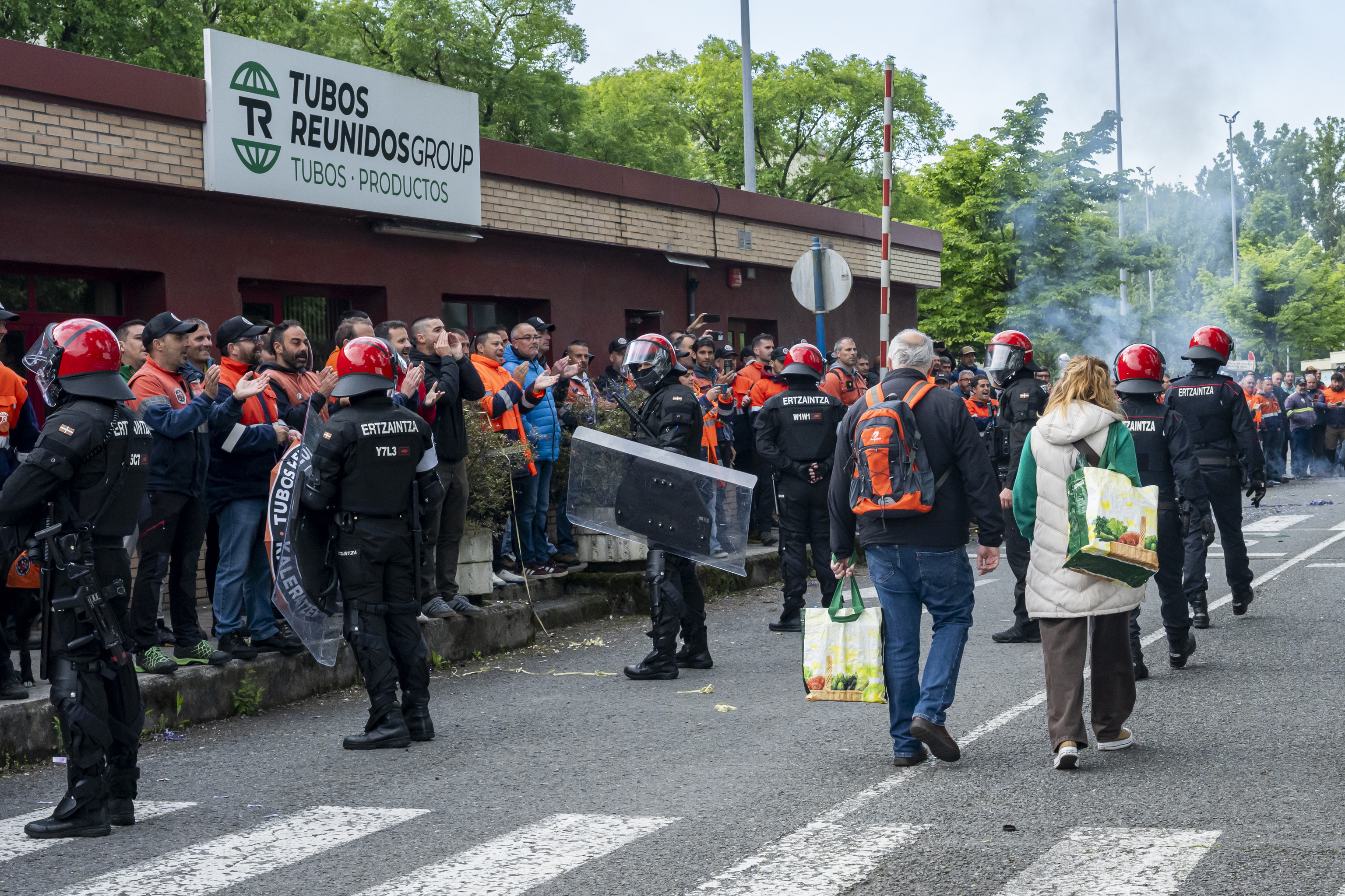 Agentes de la Ertzaintza protegen a dos trabajadores de Tubos Reunidos que acceden al interior de la f�brica de Amurrio.