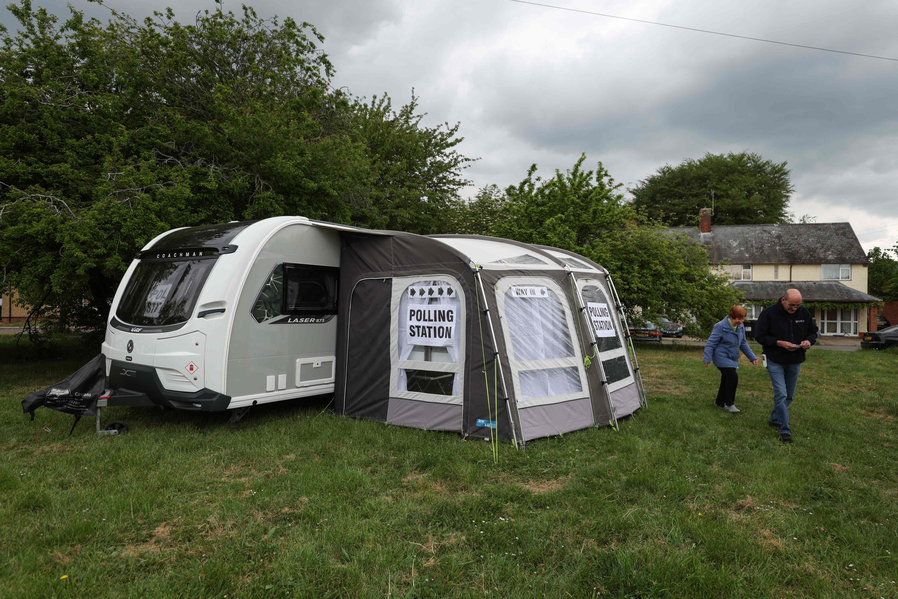 Unos vecinos acuden a un colegio electoral móvil en una caravana cerca de Duxford, en el este de Inglaterra.