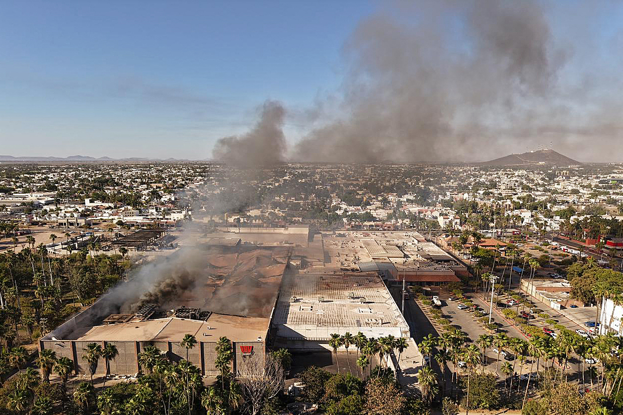 Una columna de humo sale del centro comercial incendiado en Los Mochis.