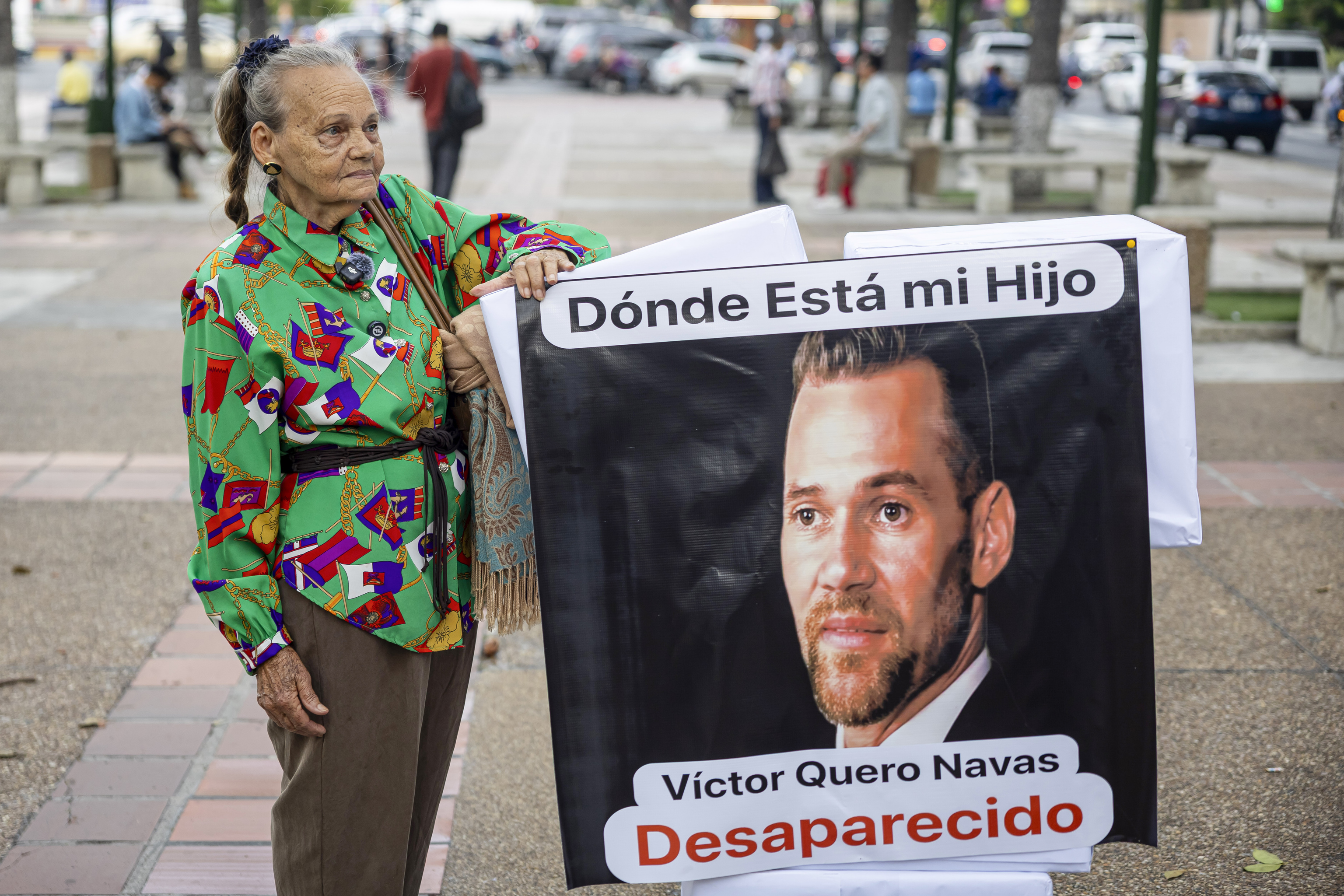 Carmen Nava sosteniendo una pancarta con la imagen de su hijo, Victor Quero.