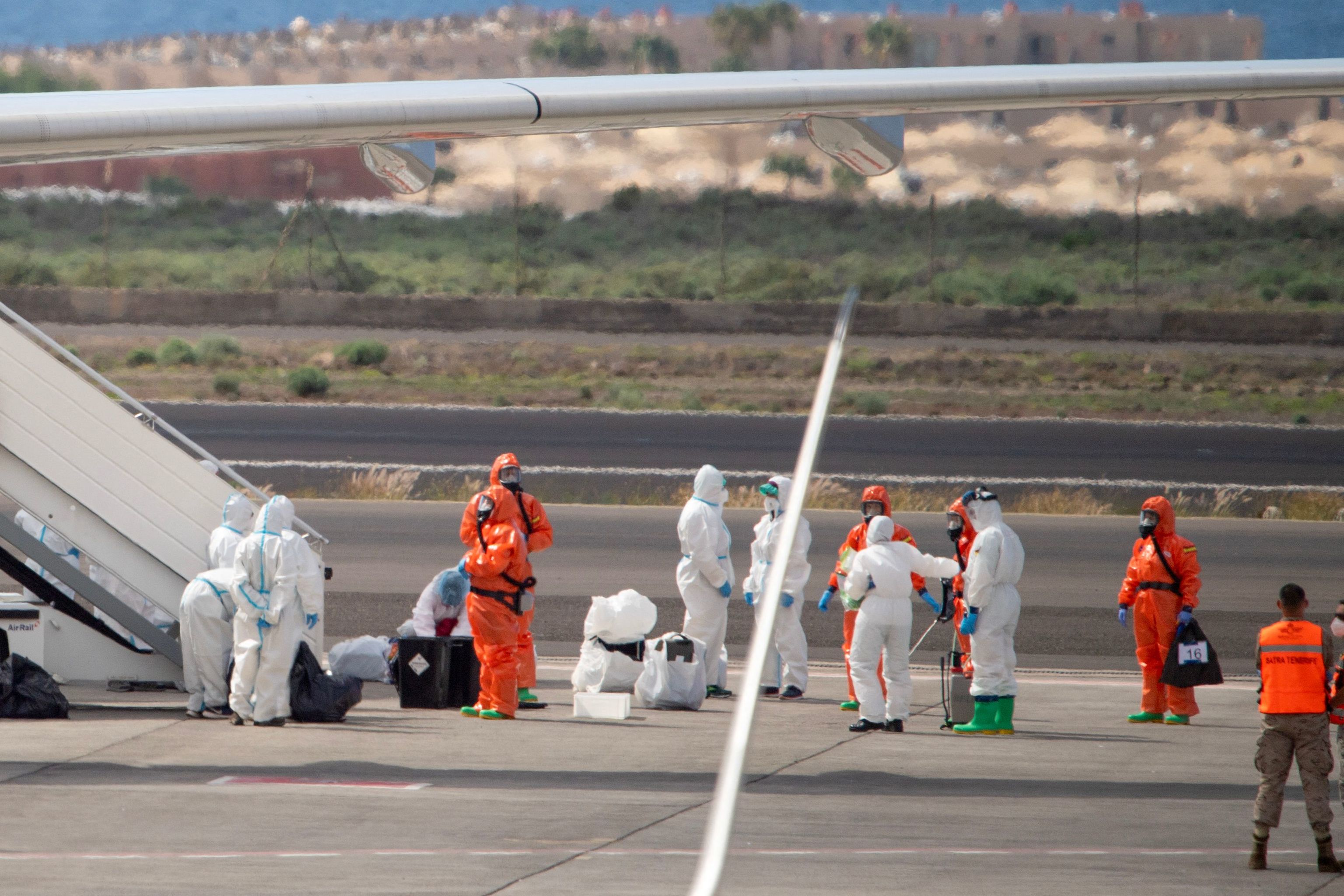 Los ciudadanos espa�oles siendo preparados por personal militar y sanitario (de Sanidad Exterior) para abordar el avi�n que los traslada a Torrej�n.