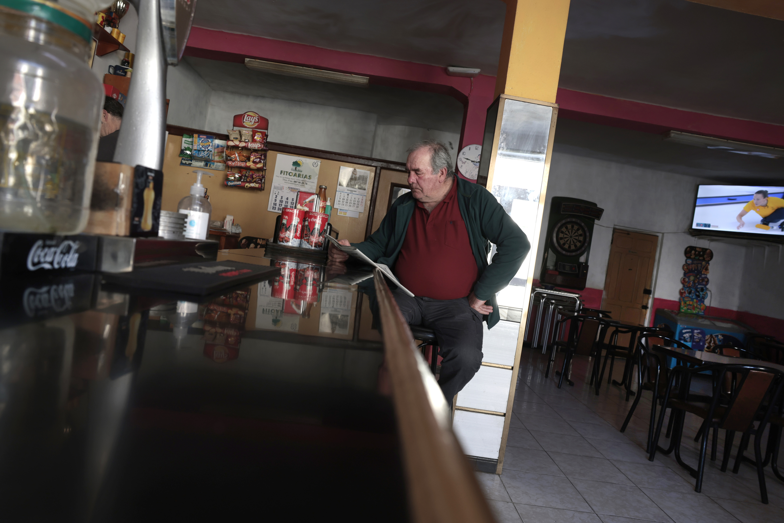 Un se�or, leyendo la prensa en un bar de Carucedo, en Le�n