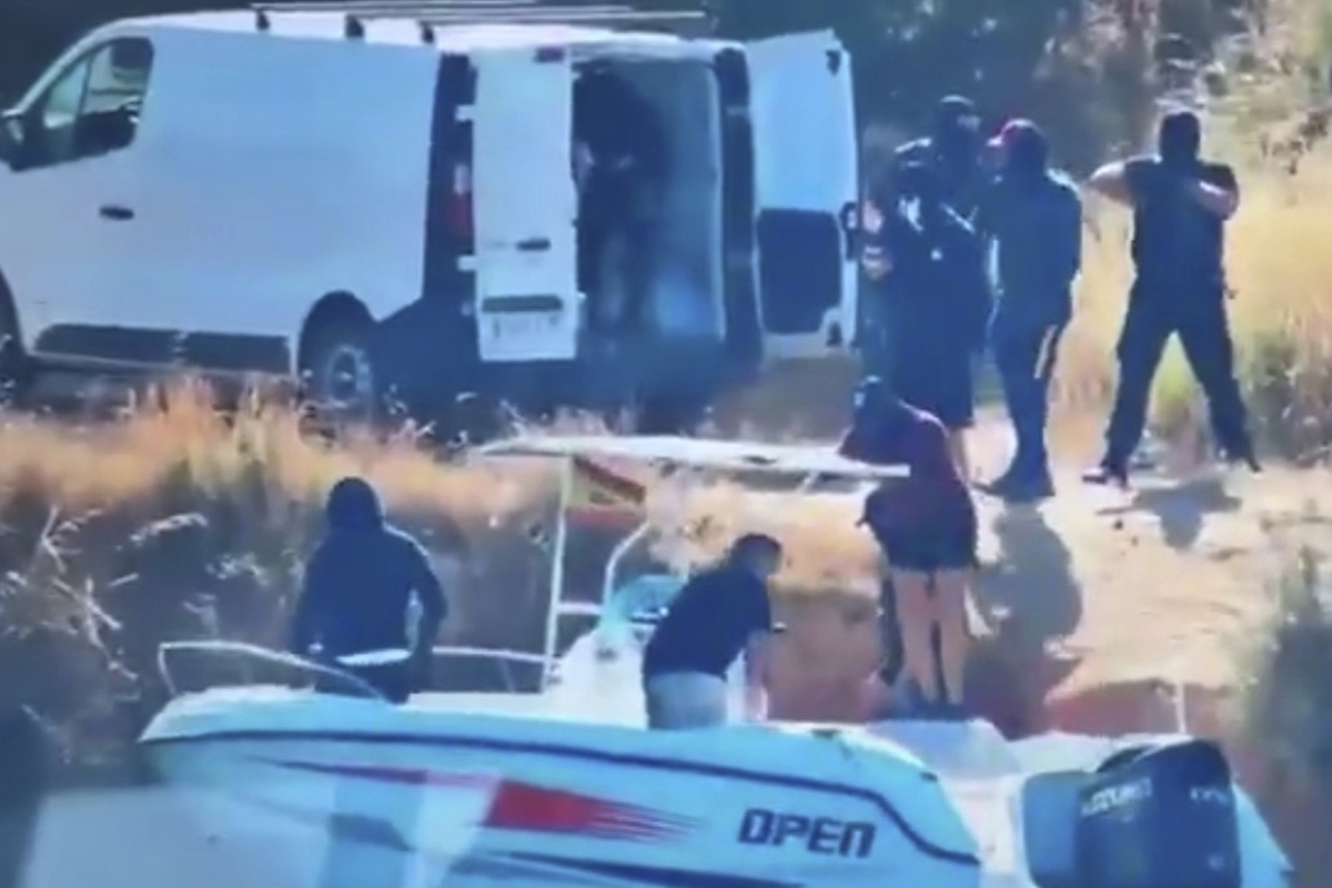 Momento del alijo de la embarcación 'Open'. Los narcos están custodiados por un equipo de tres hombres armados y vestidos con "ropajes paramilitares".