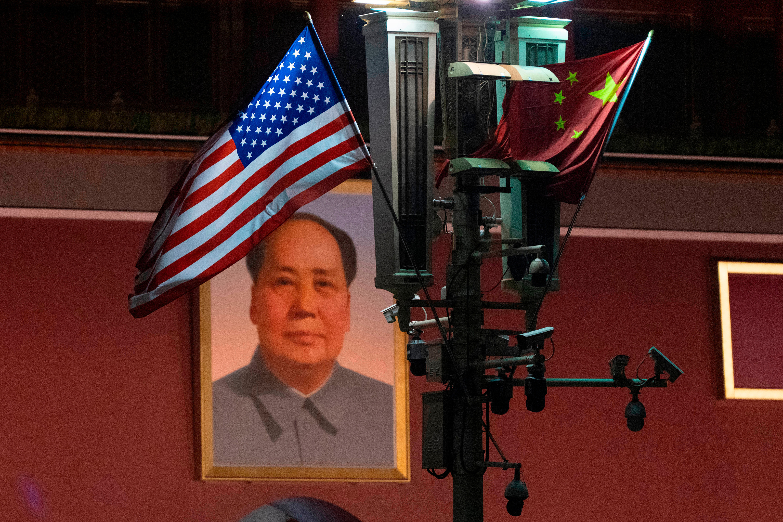 Barderas chinas y estadounidenses frente a un retrato de Mao Zedong.