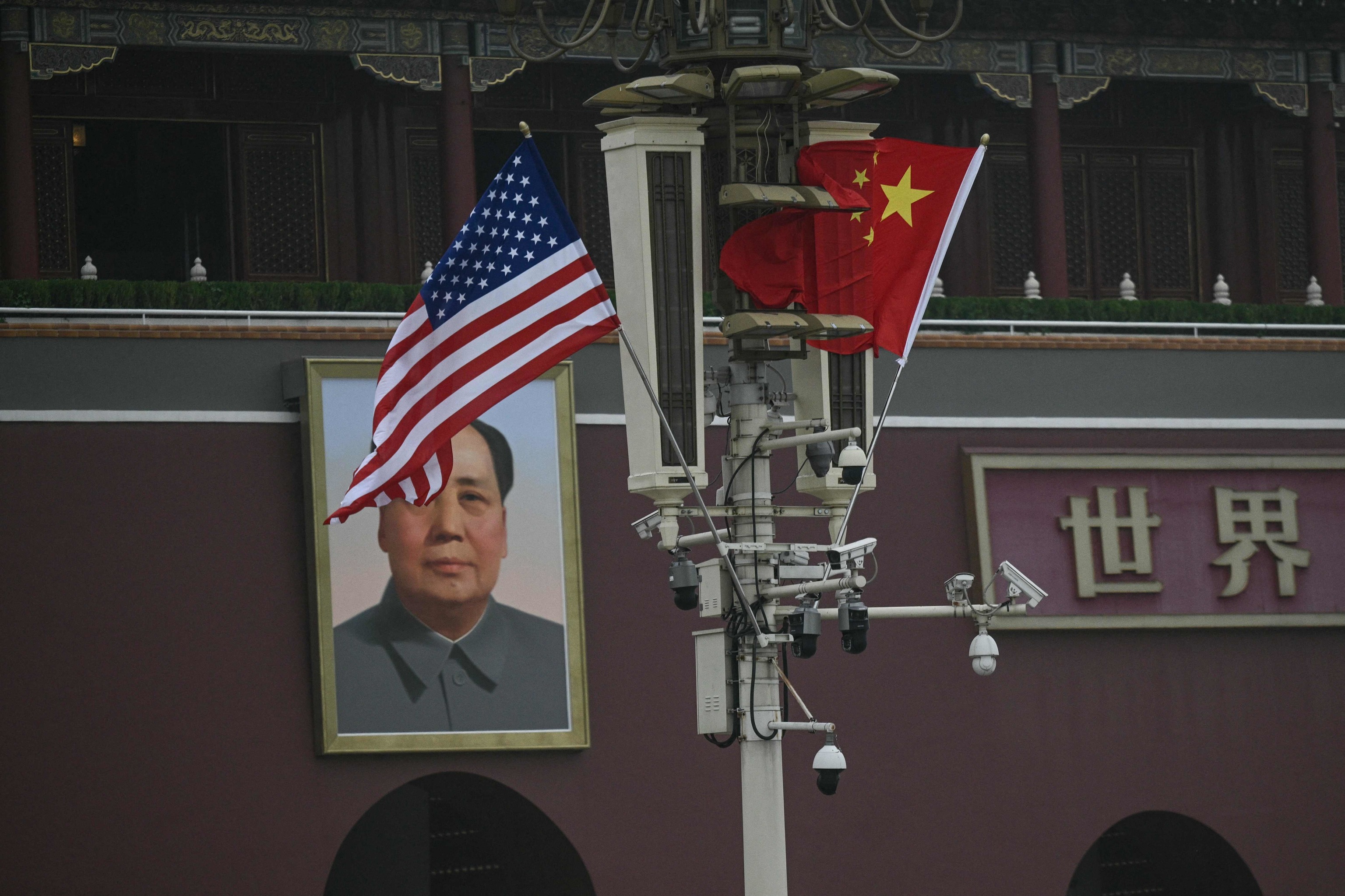 Banderas chinas y estadounidenses frente a un retrato de Mao Zedong.