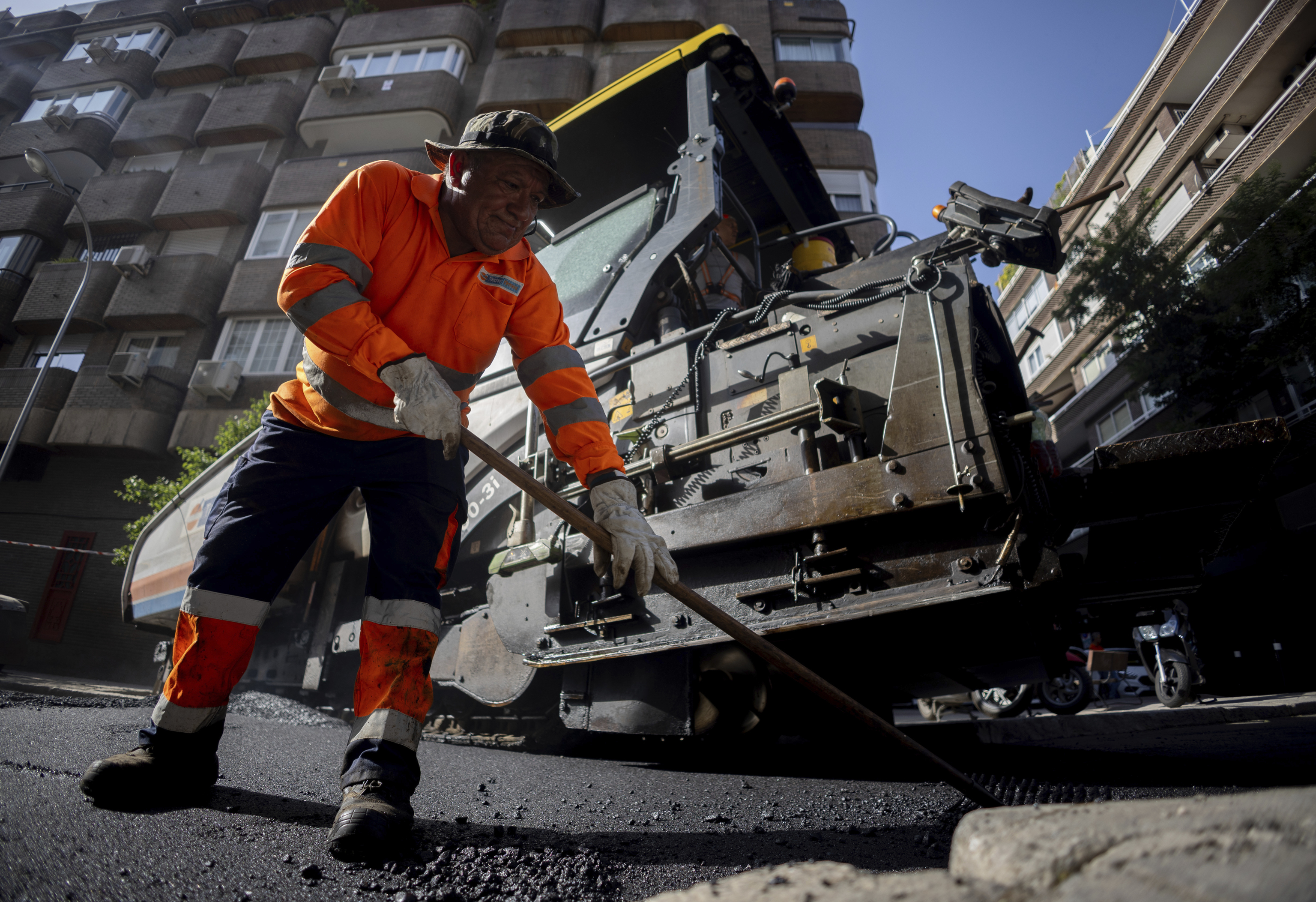 Un operario extiende el asfalto en Madrid durante la campa�a de 2025.