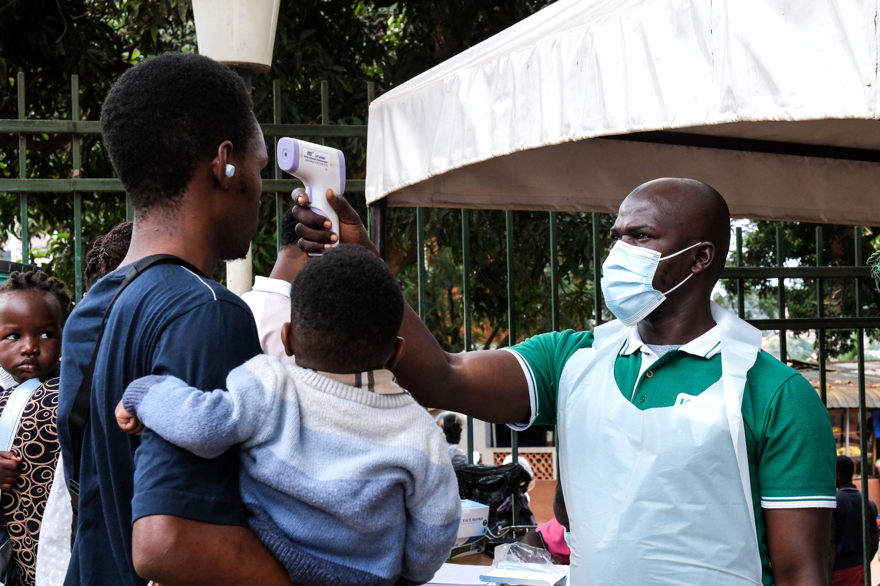 Un trabajador sanitario revisa la temperatura frente al Hospital Musulmán Kibuli en Kampala, Uganda.