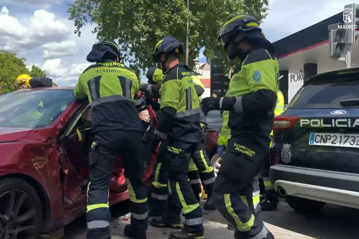 Bomberos tratando de excarcelar a la conductora herida en el choque.