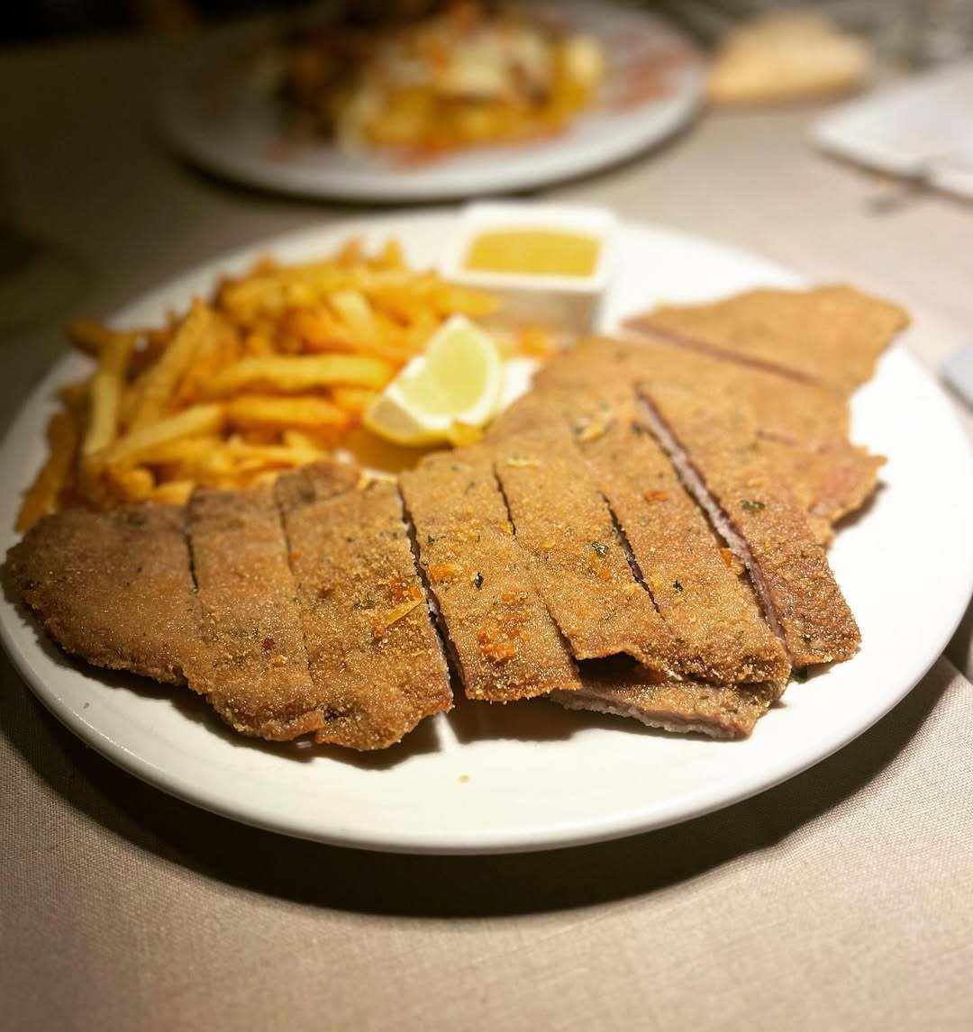 Milanesa de ternera asturiana con patatas fritas en Camino.