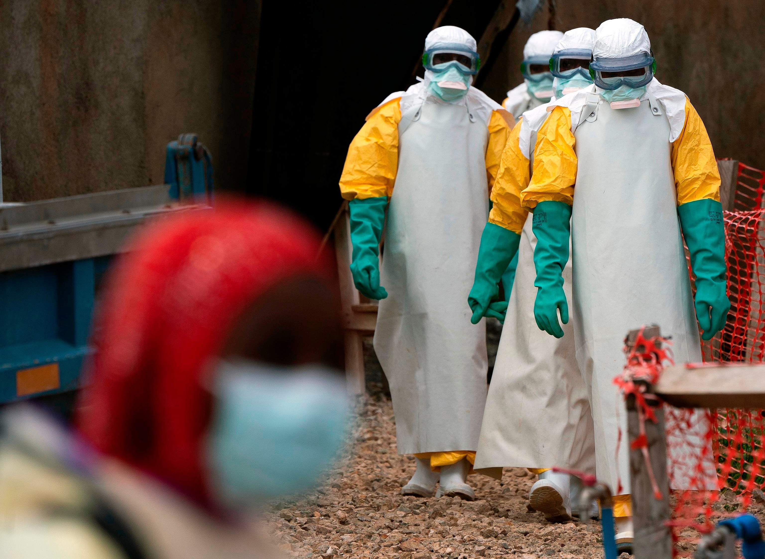 Trabajadores de la salud vestidos con equipo de protección inician su turno en un centro de tratamiento del ébola en Beni, Congo.