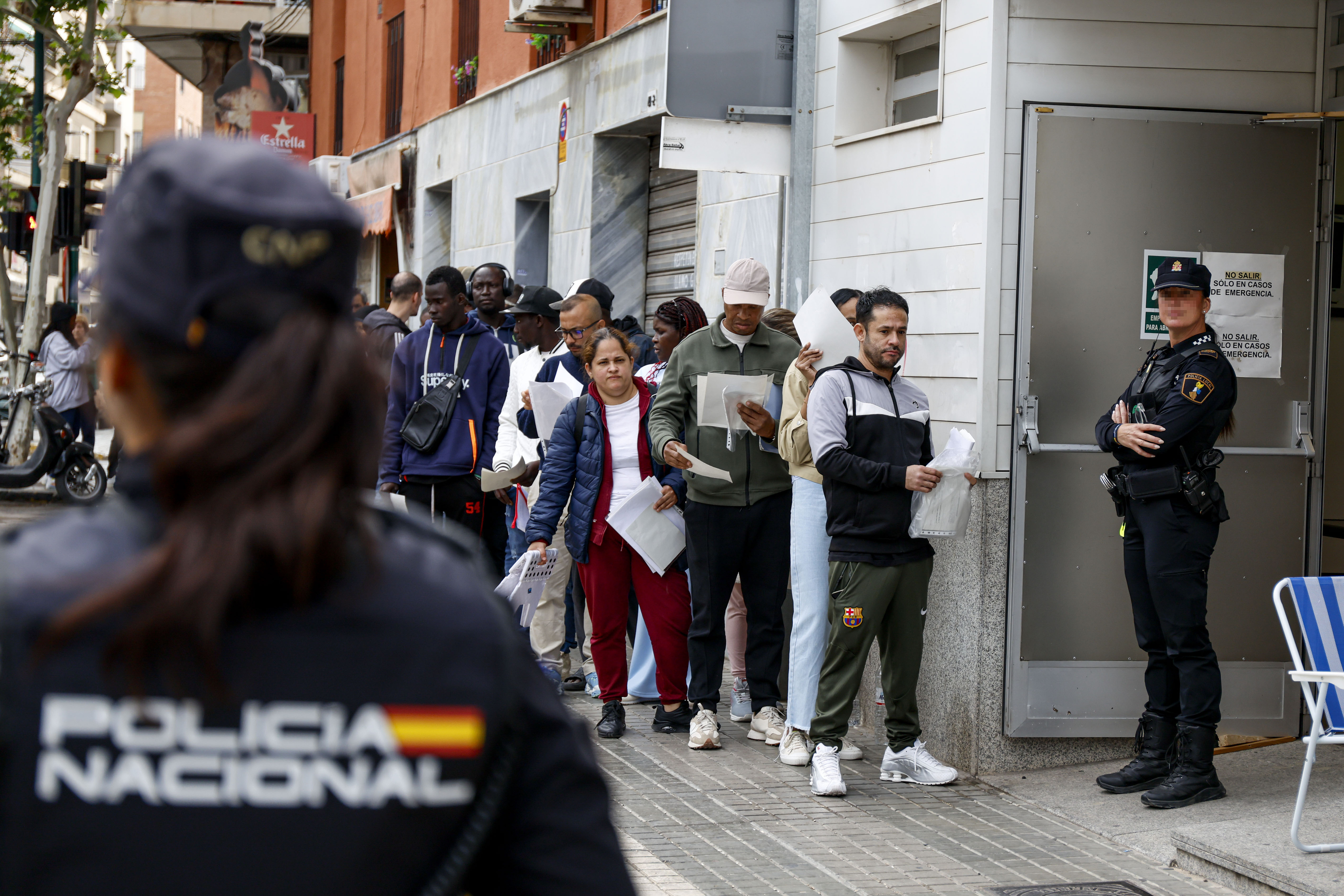 Decenas de personas hacen cola para presentar documentaci�n dentro de su proceso de regularizaci�n